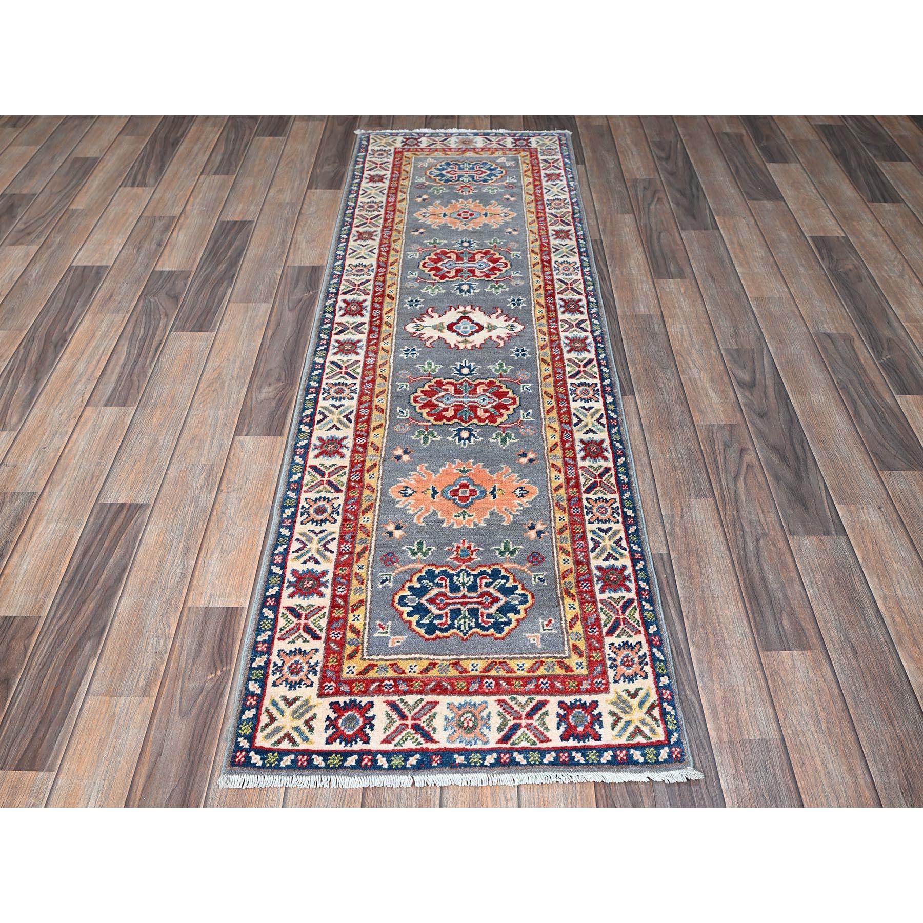Gris tourterelle, Kazak avec motifs de médaillons tribaux, laine douce et veloutée, nouée à la main, tissage plus dense, teintures végétales, chemin de fer étroit, tapis d'Orient
Matières premières : Laine
Latex : Pas de poils 
hauteur : 0,25