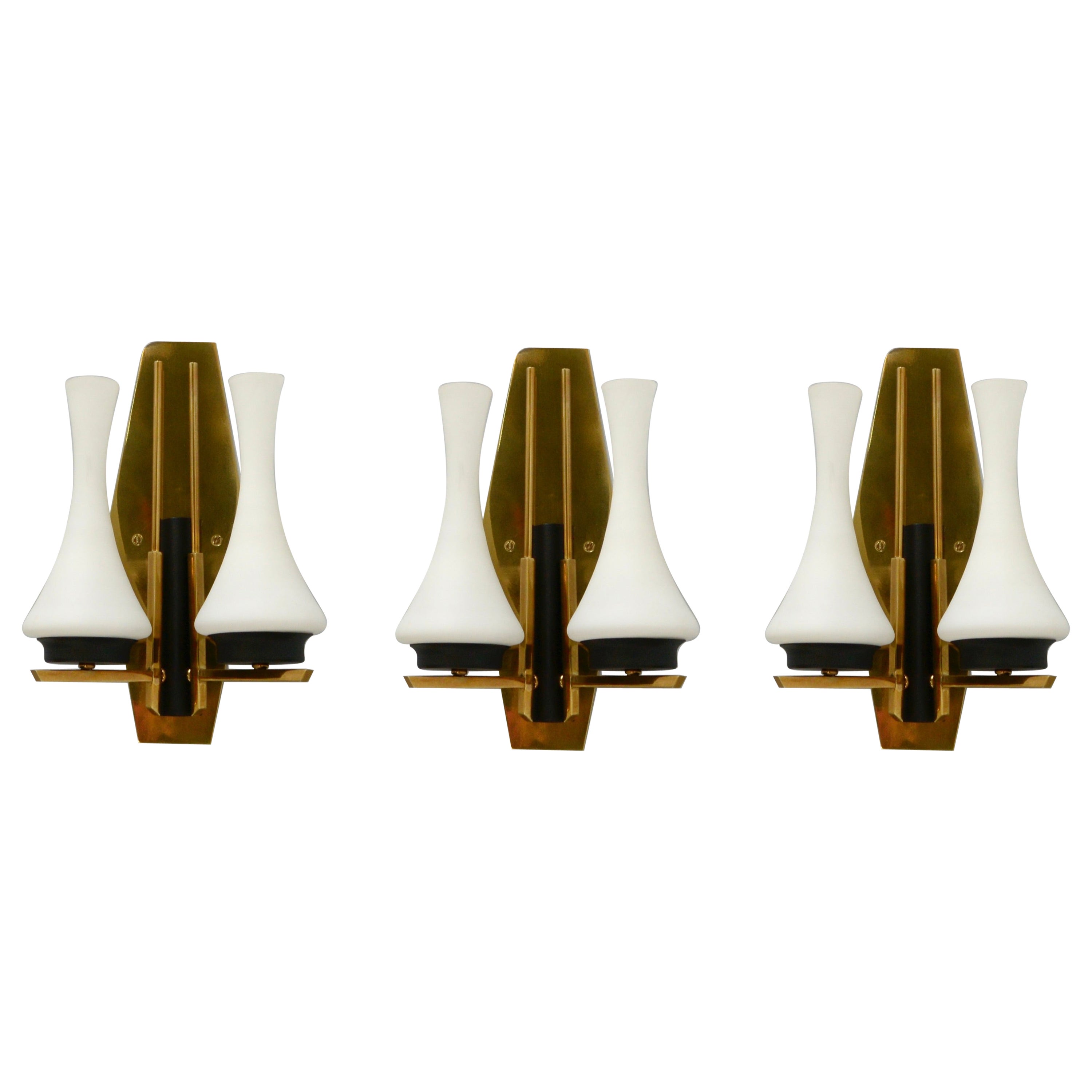 3 Mid-Century Modern Italian Silhouette sconces from the 1950s. These sconces have a lightly patinated brass finish, painted aluminum and steel and original glass shades. They are restored with 2 E12 candelabra based sockets per sconce, for use in