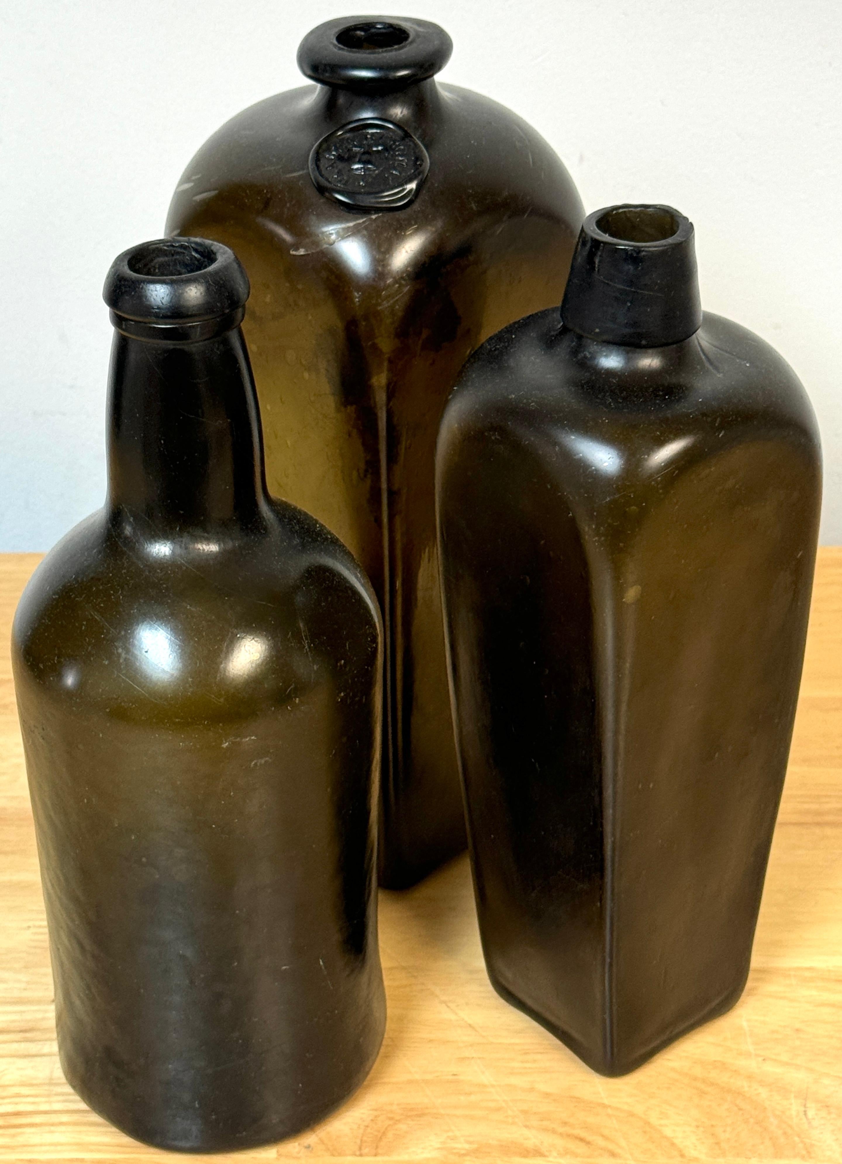 3 19th-century shipwreck olive green glass liquor bottles, Van Den Bergh & Co. et al. 
Provenance unknown shipwreck off the coast of Key West, FL, in the 1970s. 

This rare set of three 19th-century shipwreck olive green glass liquor bottles