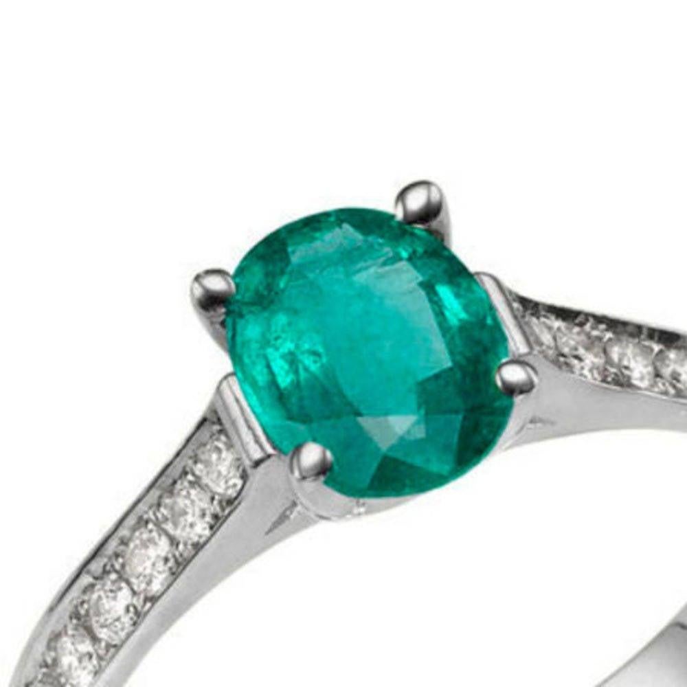 A handmade solitaire with accents Emerald engagement ring made of 14K White Gold set with a Round cut Emerald of 0.50 carat accented by 14 natural round diamonds.
 
 The center stone of this unique engagement ring is of excellent cut and green