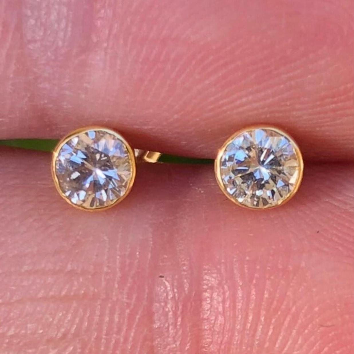 Classic near 1 carat solitaire diamond stud earrings in 14k yellow gold. Pair of natural earth-mined round brilliant diamonds weighing approx. .7 carats are bezel set in these 14K gold basket studs.

Diamond stud earrings come with solid 14k gold