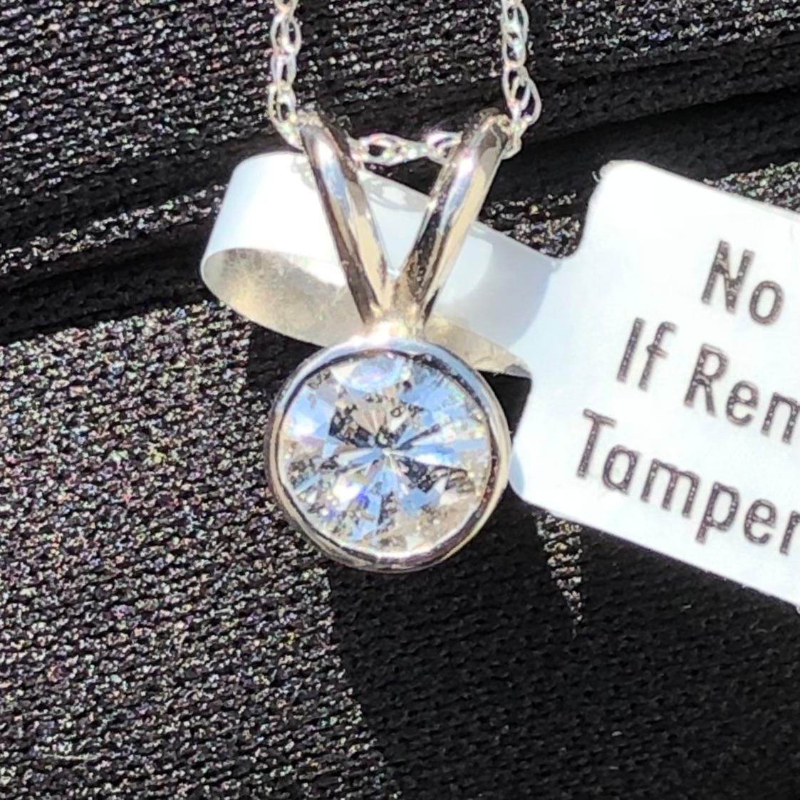 Classic 3/4 carat solitaire round diamond pendant necklace in 14k white gold. A large center 3/4 carat brilliant round diamond (size of an engagement ring) is natural earth mined and bezel set in a pendant necklace.

Diamond solitaire pendant comes