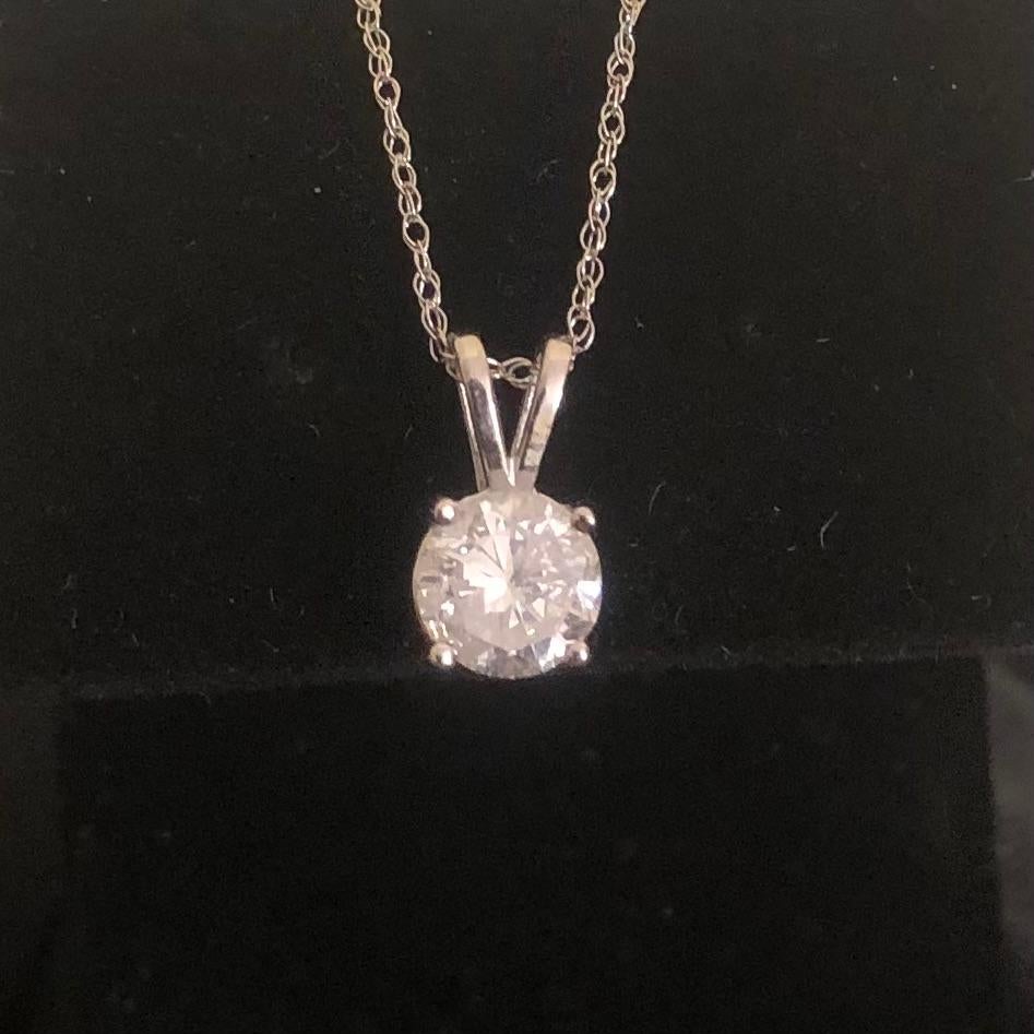 Classic 3/4 Ct solitaire round diamond pendant necklace in 14k white gold. A large center approx. 0.70 carat brilliant round diamond (size of an engagement ring) is natural earth mined and set in a 4-prong basket pendant necklace.

Diamond solitaire