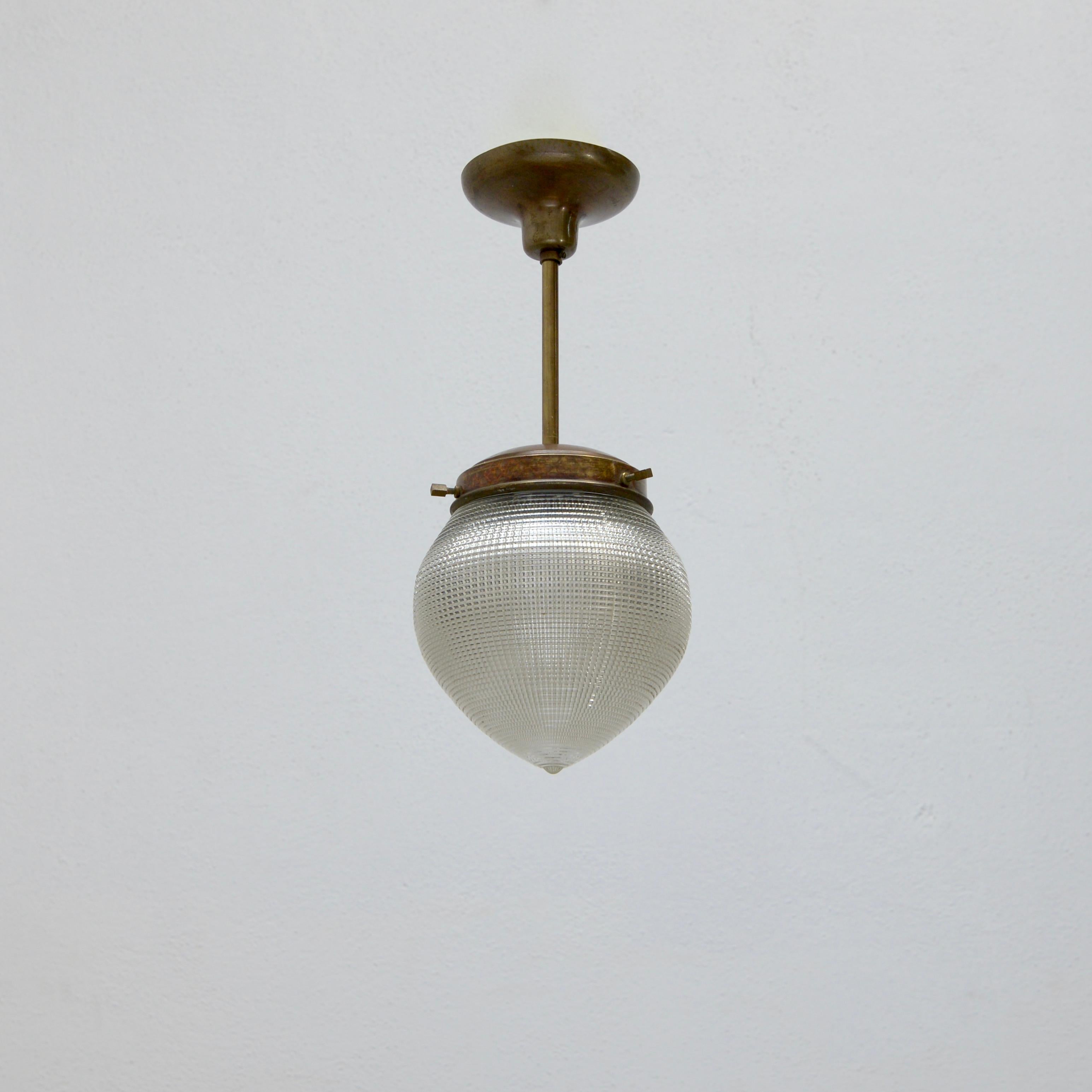 3-Charming 1940s Italian Teardrop Pendants. Partially restored in brass and holophane glass. Wired with 1 E26 medium based socket per pendant and wired for use in the US. Light bulbs included with order. Sold all together as a set.