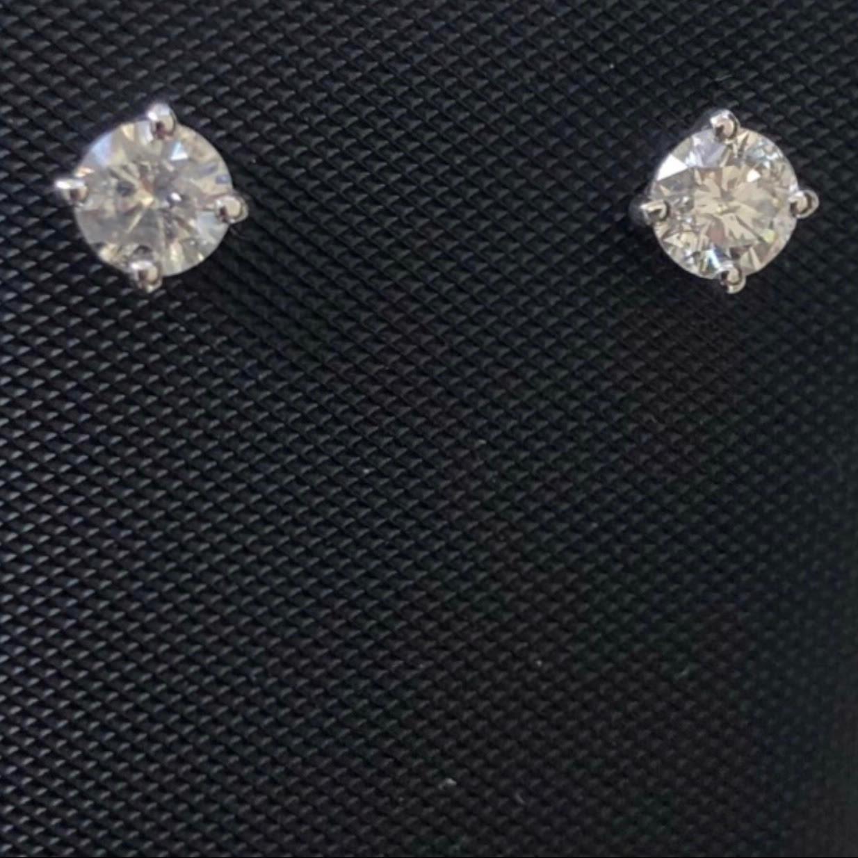 Classic 0.60 Ct solitaire diamond stud earrings in 14k white gold. Pair of natural earth-mined round brilliant diamonds weighing approx. 0.60 carat are prong set in these 14K gold basket studs.

Diamond stud earrings come with solid 14k gold push