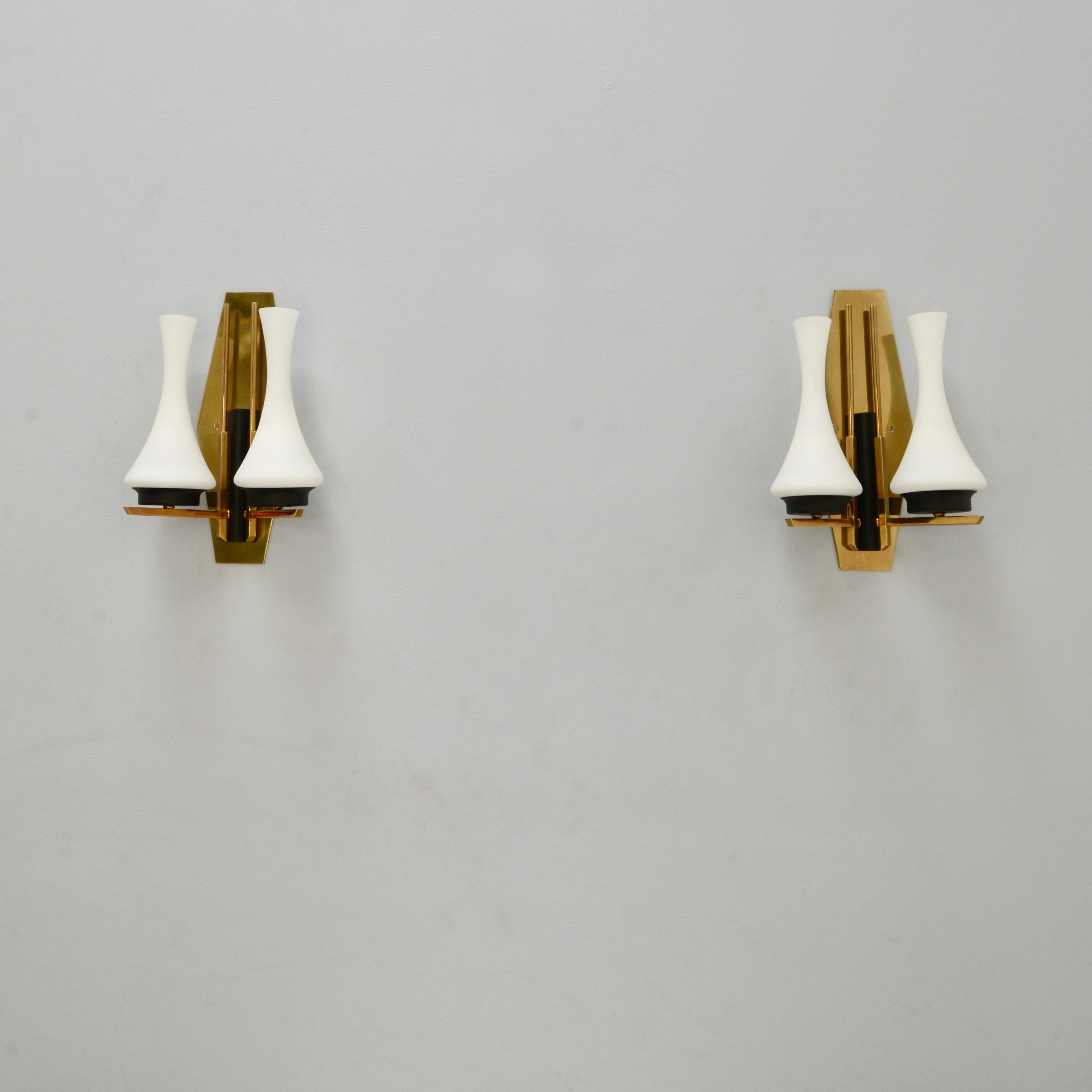 3 Mid-Century Modern Italian Silhouette sconces from the 1950s. These sconces have a lightly patinated brass finish, painted aluminum and steel and original glass shades. They are restored with 2 E12 candelabra based sockets per sconce, for use in