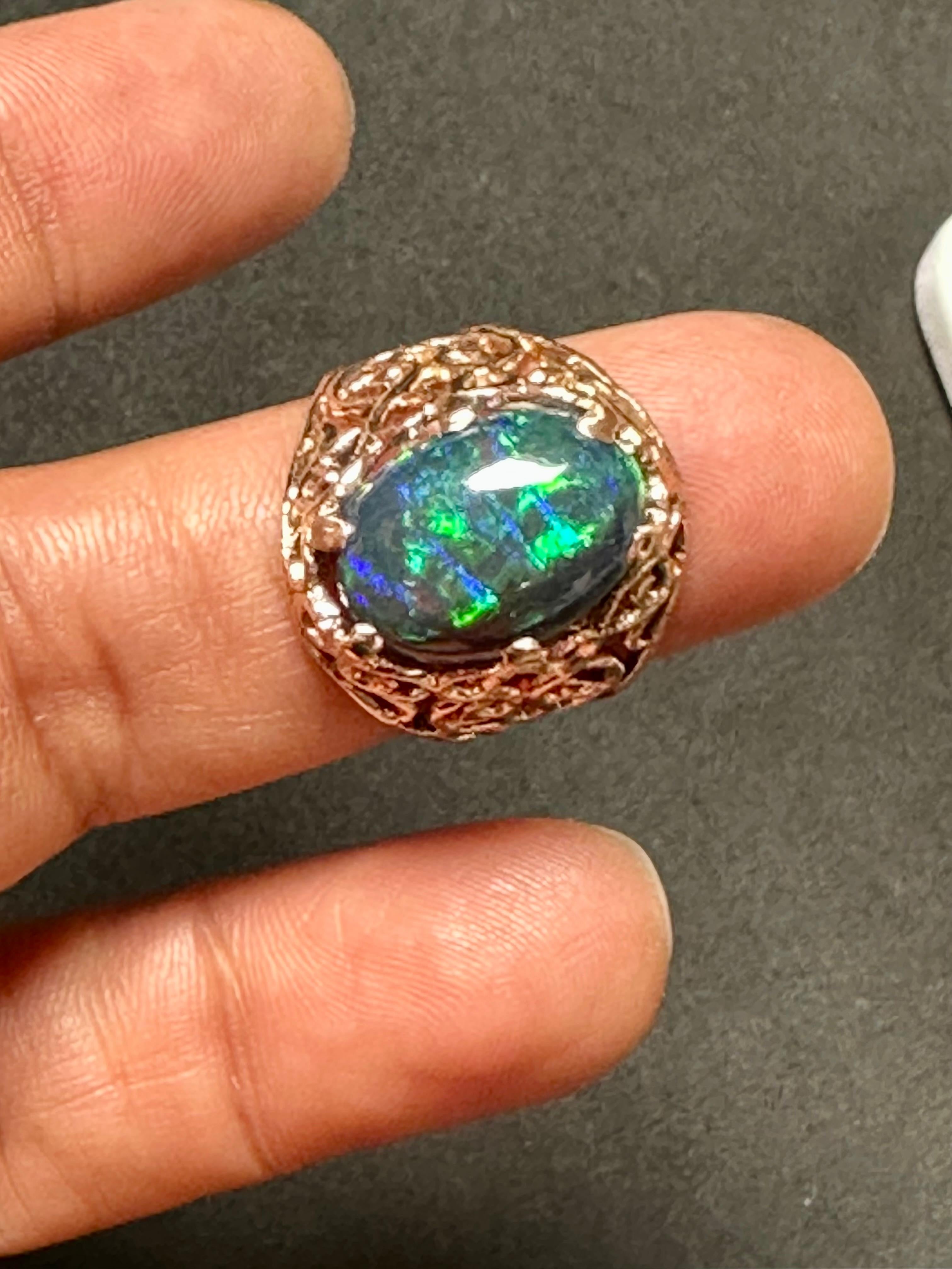 Presenting our stunning 14 Karat Yellow Gold Oval Shape Black Australian Opal Cocktail Ring, featuring an impressive 3.5 carat oval opal with magnificent shades of green, blue, and red. This exceptional ring showcases the opal's natural beauty with