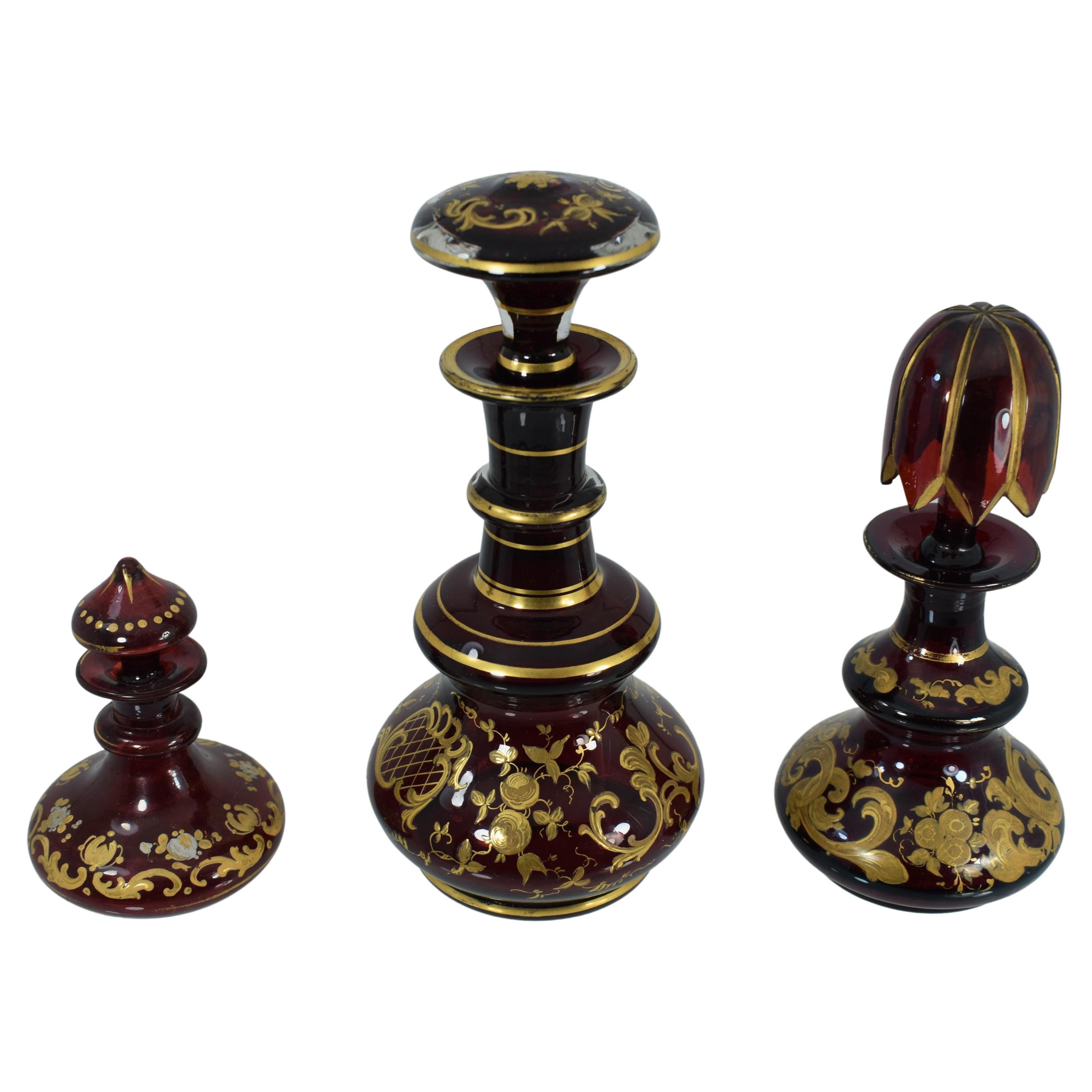 3 perfume bottles (flacon) in ruby red blown glass, decorated all around with gilded enamel scrollworks and flowers
further gilding on the neck and stopper
Bohemia, 19th Century
Largest one is 18.5 cm high.