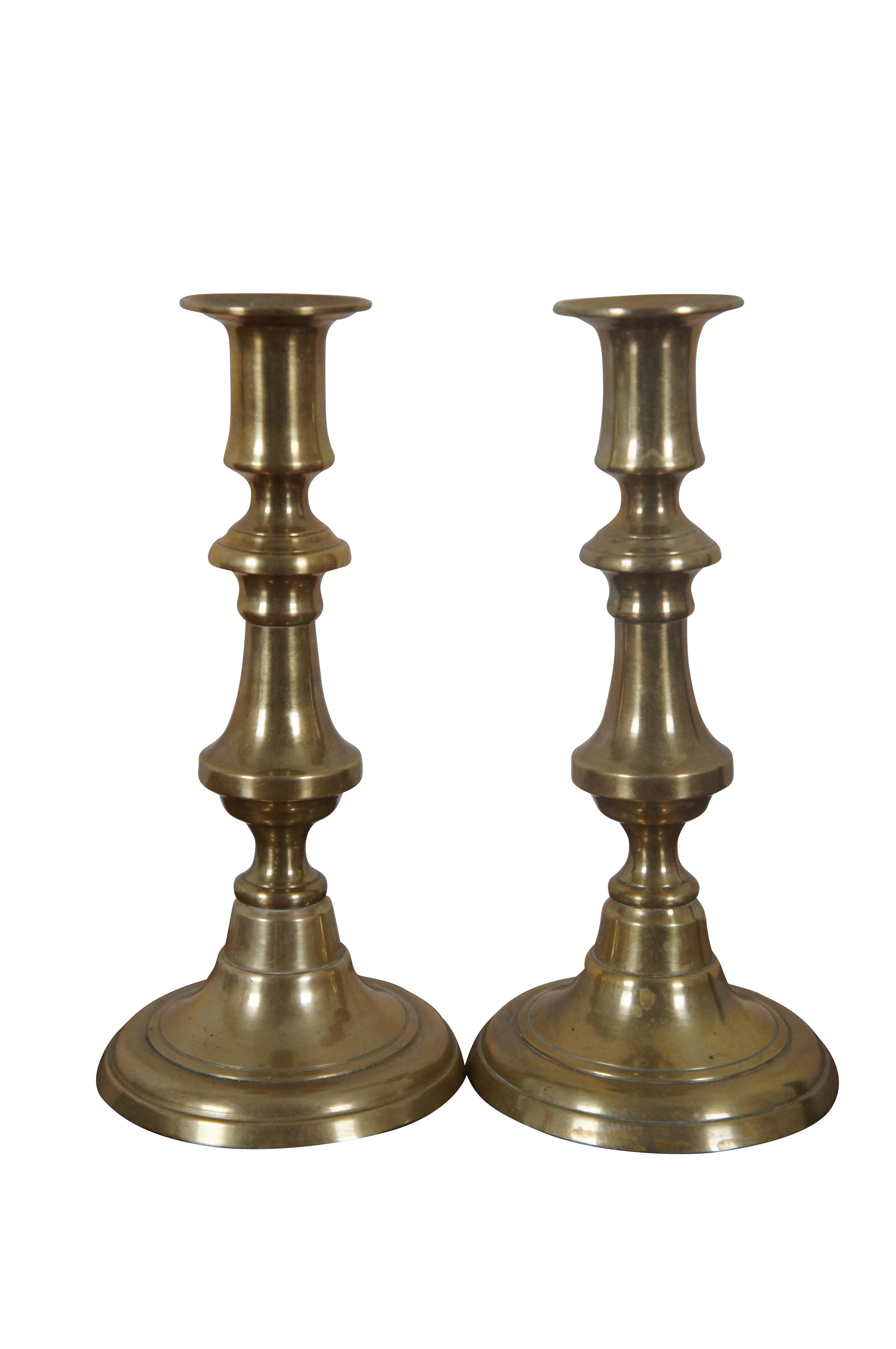 Three antique English brass candlesticks or candle holders featuring Queen Anne styling with push up rods.

Dimensions:
Tall - 3.75