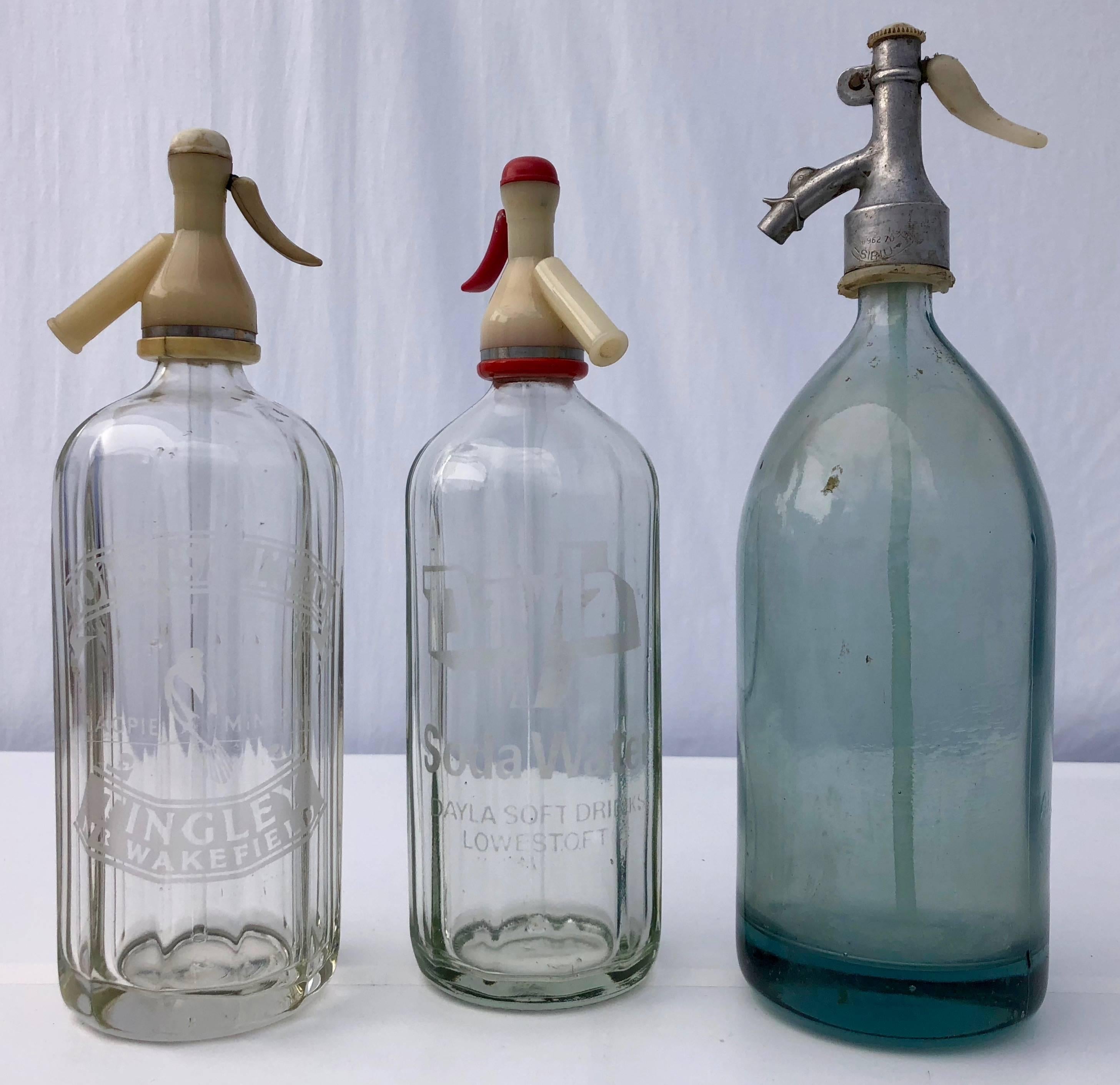 This is a set of 1940s three beautiful old soda bottles made of heavy pressed glass. The two transparent glass bottles are both etched. One bottle etching reads- soda water Dayla Sodawater Lowestoft, Gomersall's ltd. The other etched bottle reads