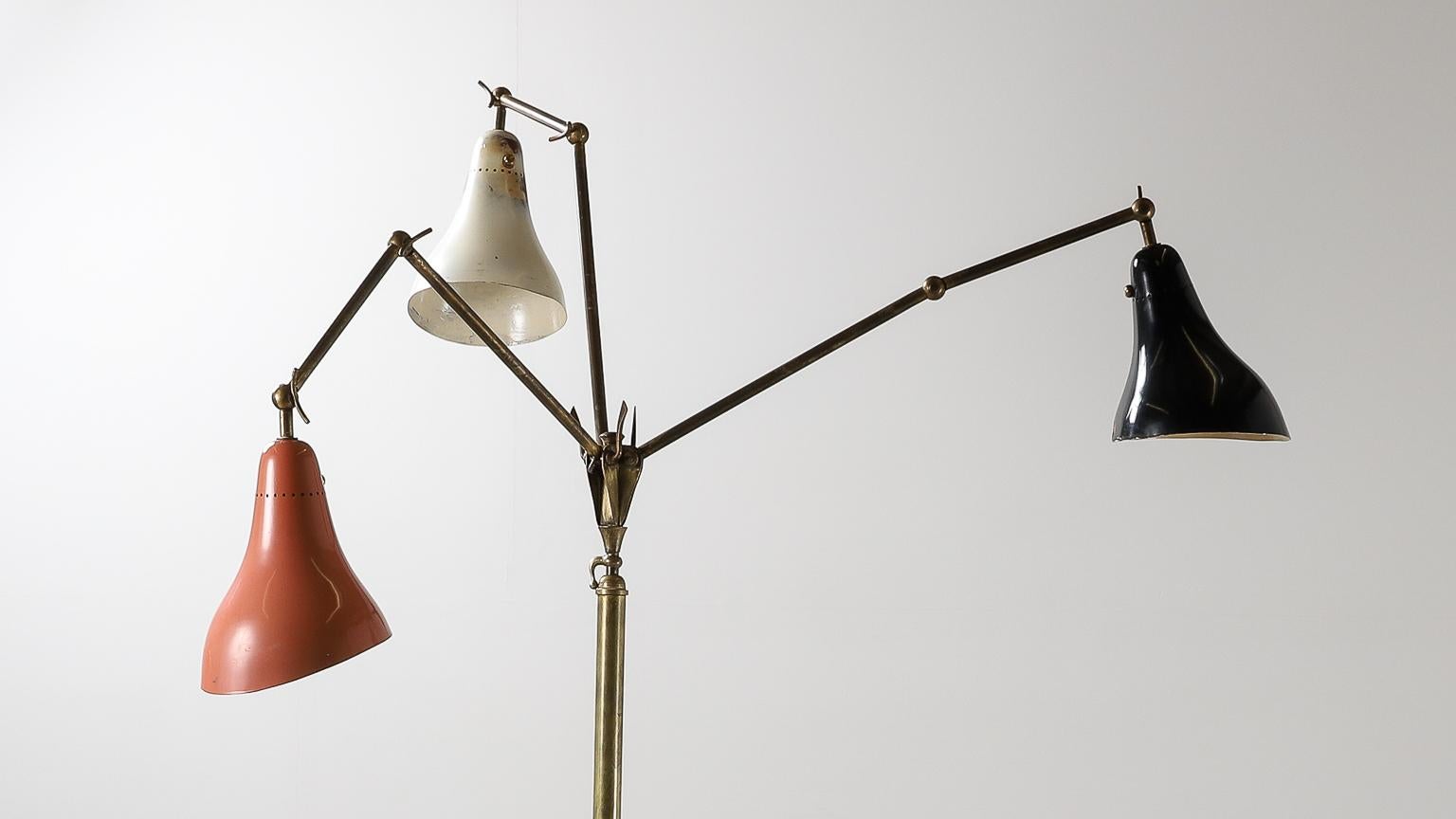 3-arm floor lamp designed by Stilnovo, 1950s. Brass & metal, with lacquered metal base & original paint. Shades articulate in various positions and heights are adjustable.

H 160-200cm x W 150cm
Base DIA 31cm
Shade DIA 18cm x 22cm

Italian