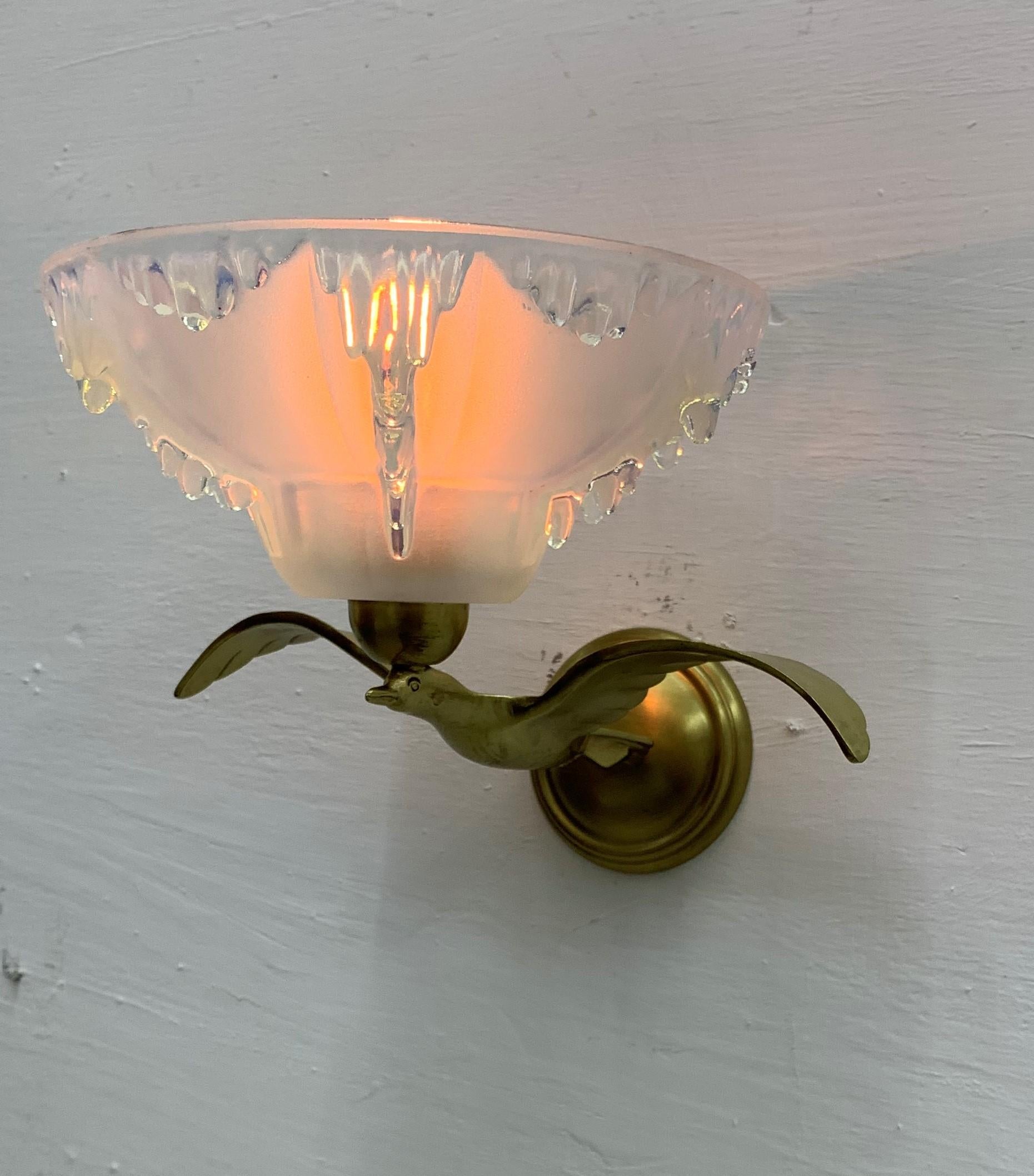 3 Art Deco sconces in the shape of birds holding an opalescent moulded glass shade signed by Ezan.
Priced individually.