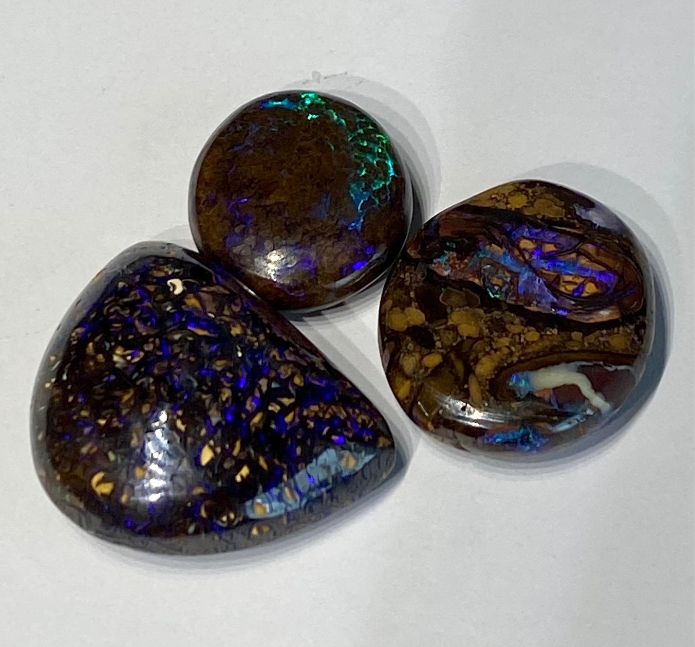 A collection of 3 Australian Boulder Opals with intense blue and green ripple effects as they move in the light. These 3 stones weigh a total of 75.24 Carats