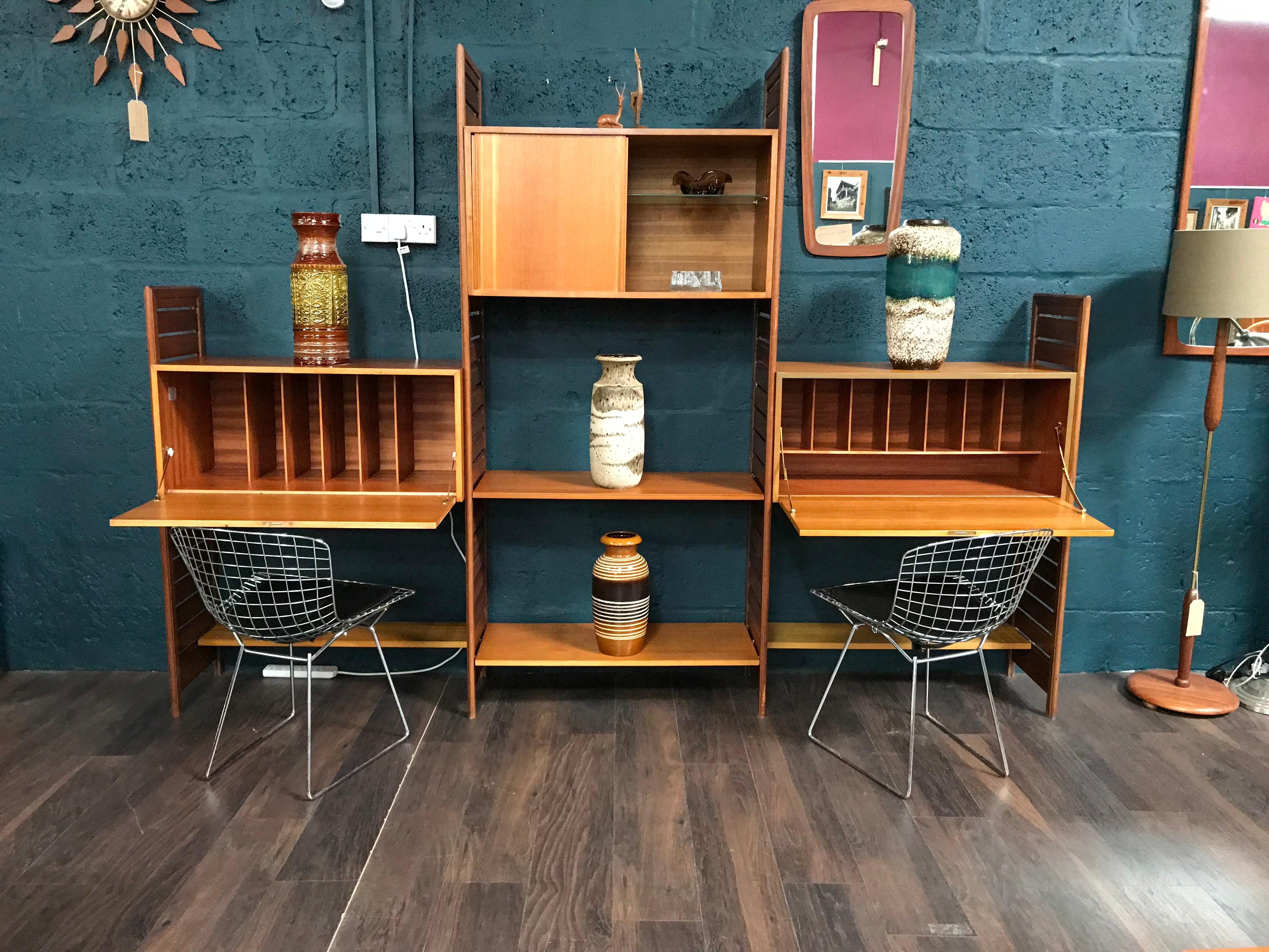 Stylish and functional, this is the Classic Staples Ladderax midcentury shelving system. The wooden uprights and easy removable supports, allow the teak cabinetry to be positioned wherever required. This is a very versatile piece of retro furniture.
