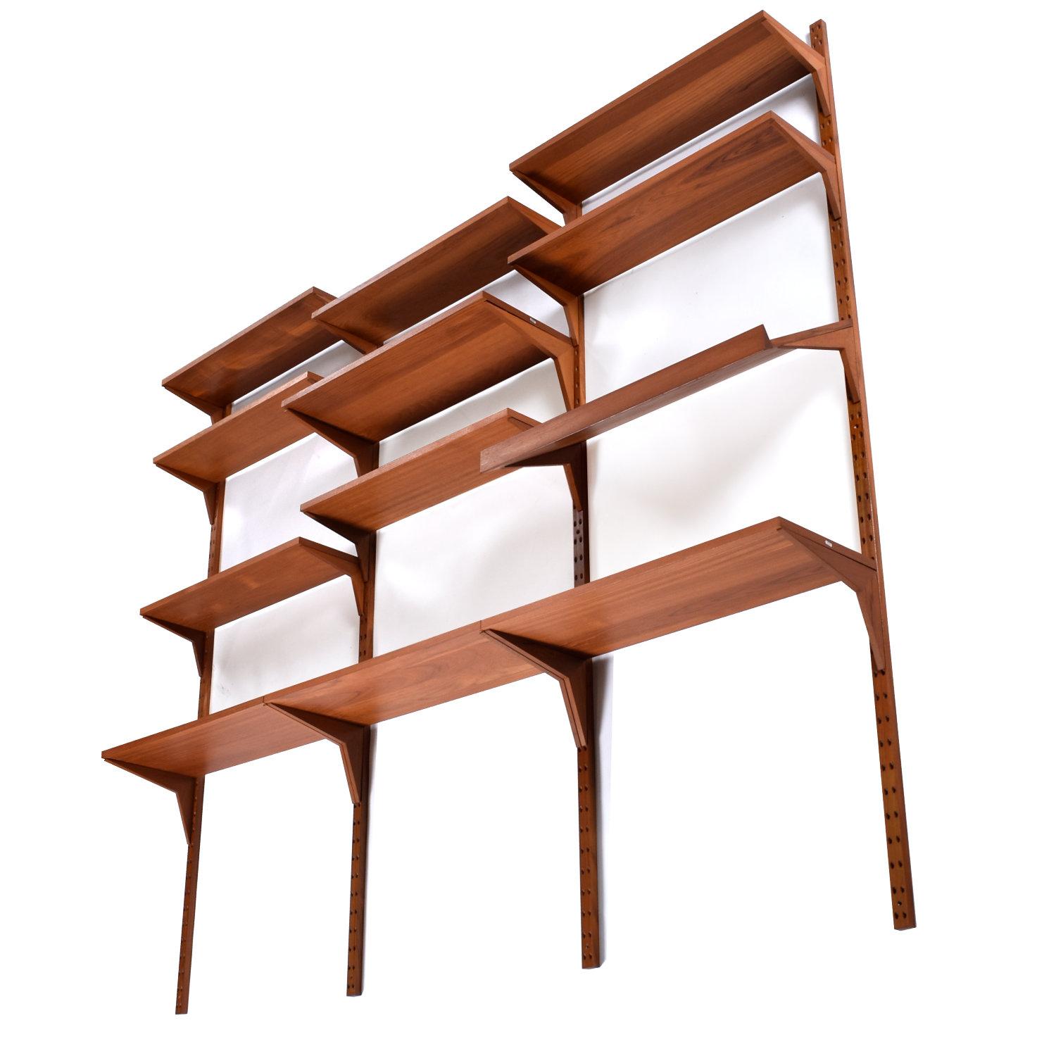 Mid-Century Modern Danish teak wall mounted shelving system designed by Poul Cadovius. The vintage 1960s Danish teak CADO wall mounted shelves come in a 3-bay configuration. The system is modular. The ingenious design allows one to easily customize