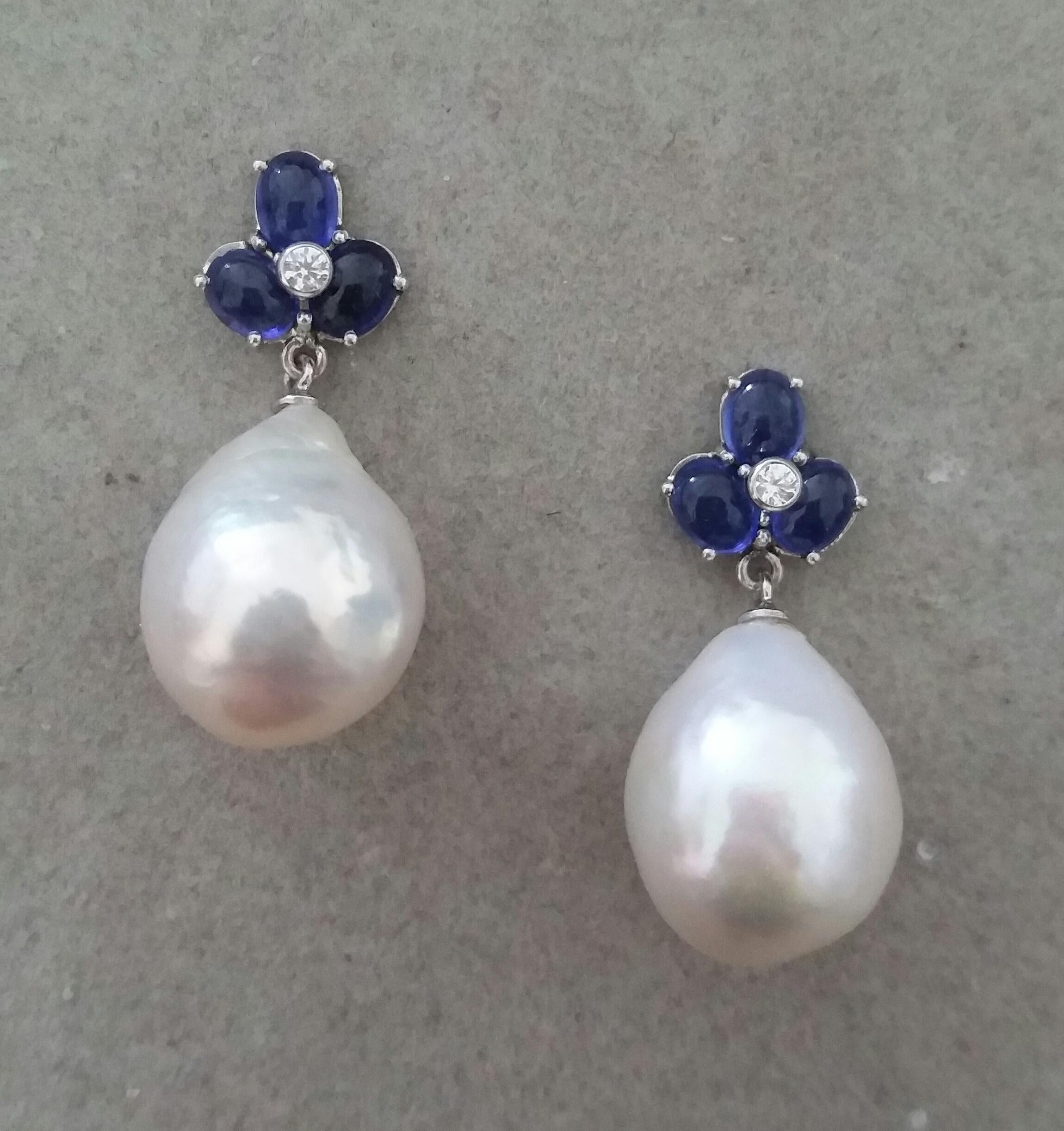 Elegant and completely handmade Earrings consisting of an upper part of 3 oval shape Blue Sapphires 4 mm x 5 mm set together in 14 Kt yellow gold with 2 small diamonds in the center, at the bottom 2 nice big size white color and high luster Pear