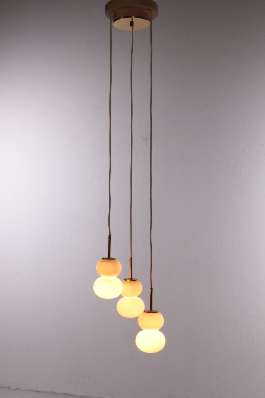 Doria Pendant lamp Model Pumpkin Cascade, 1960s Germany

Vintage ceiling lamp with three opal glass spheres, 1960 Germany

The pendant lamp canopy, the central parts of the power cords and the lamp holders show off an electrophoretic brass finish,