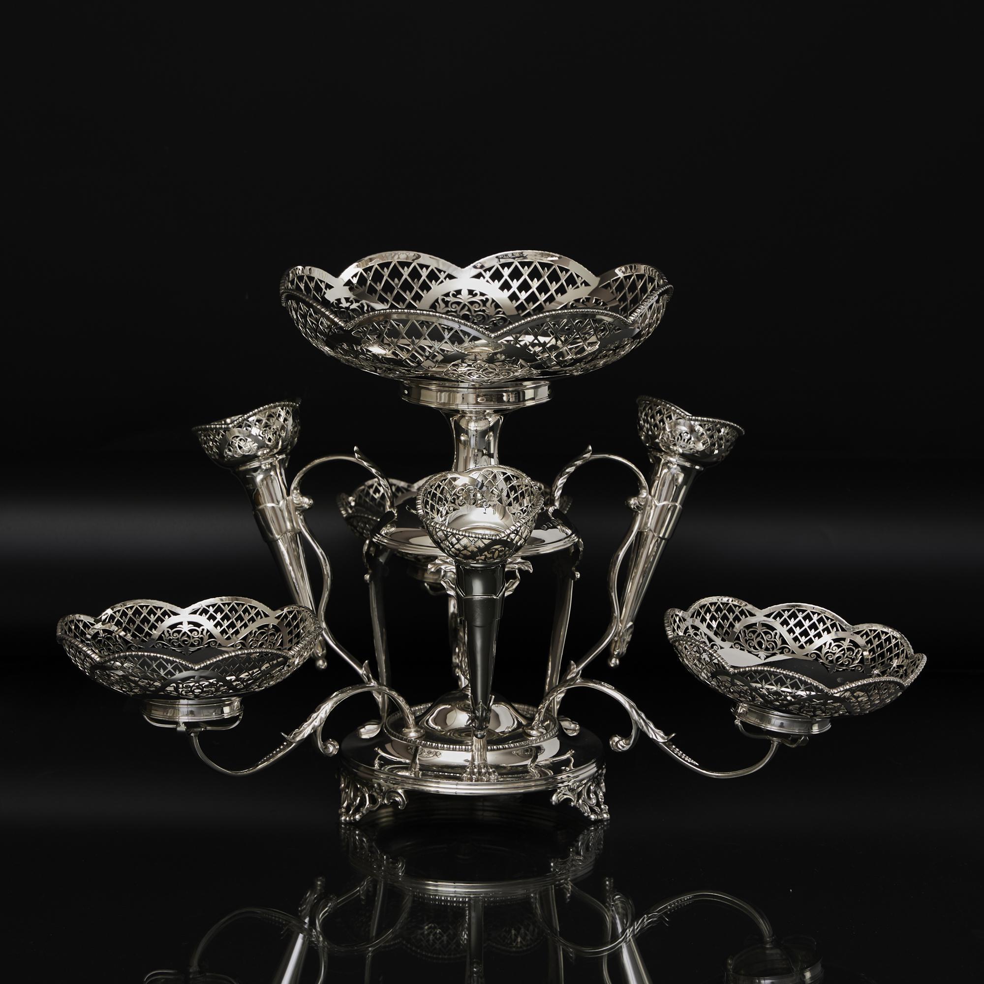 Centre de table polyvalent en argent ancien, composé d'un grand plat central et de trois plats détachables en argent et de vases en forme de cône, chacun joliment décoré de bordures percées à la main dans un motif de treillis et de bourgeons. Les