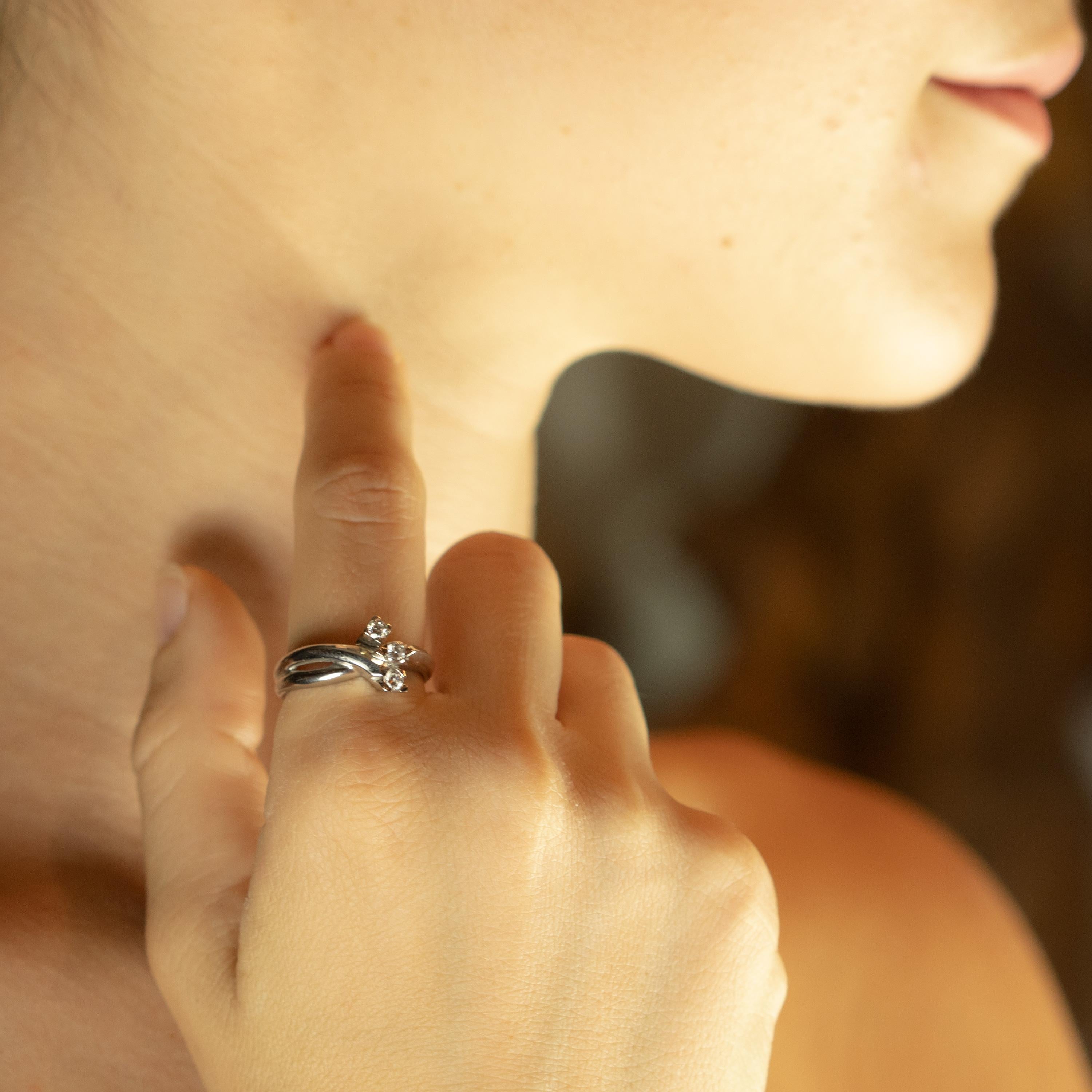 Un design unique qui développe de l'or 18 carats s'entrelaçant et formant une pièce unique, ornée de trois diamants pour un total de 0,24 carats. Si vous cherchez une bague de mariage, de fiançailles ou simplement une bague fantaisie et délicate,