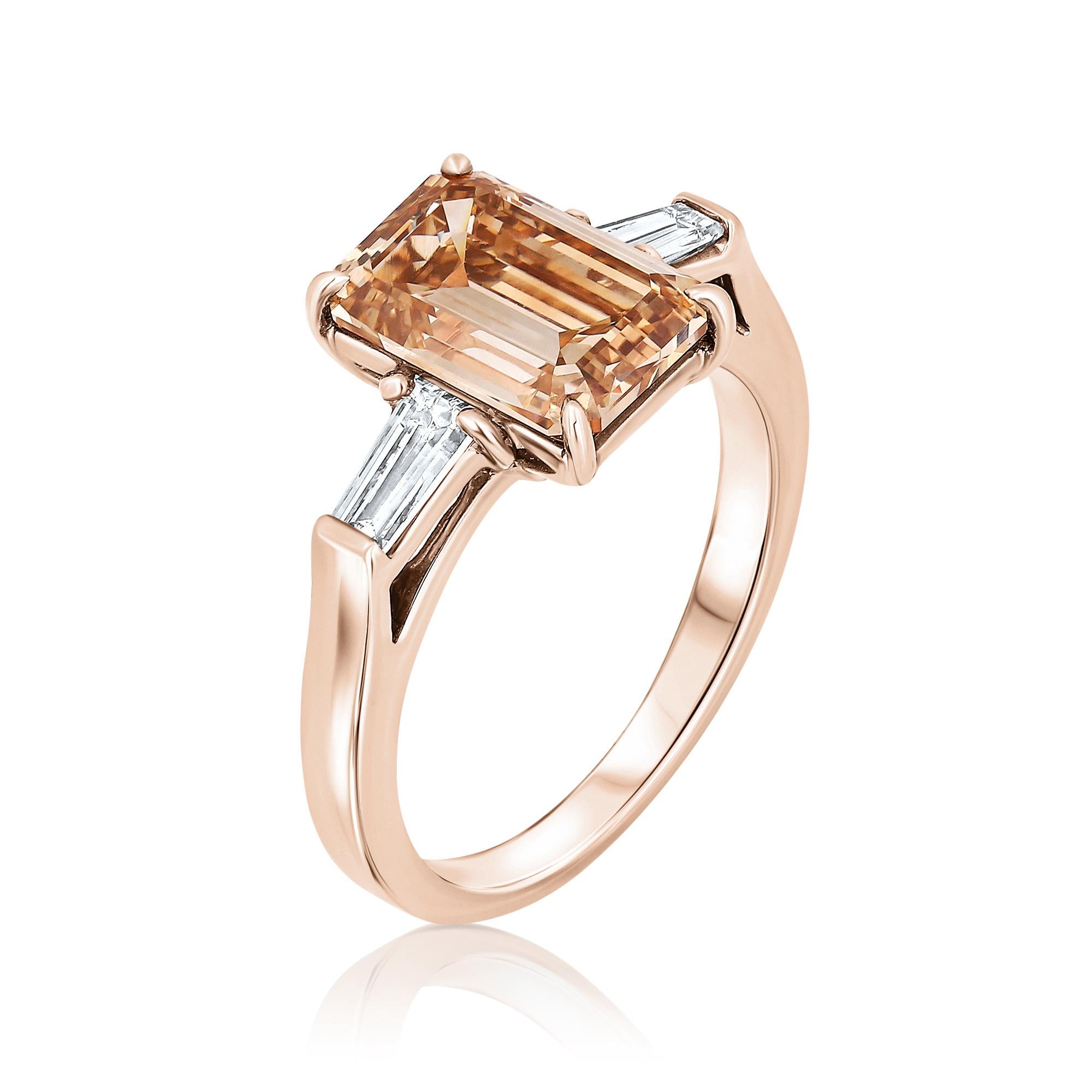 A gorgeous Three-Stone Engagement Ring featuring a 3.03-carat, Emerald-cut diamond GIA certified as Fancy Light Yellowish Brown color. The center diamond is elegantly accompanied by two Tapper-cut diamonds with a combined weight of 0.41 carats. The