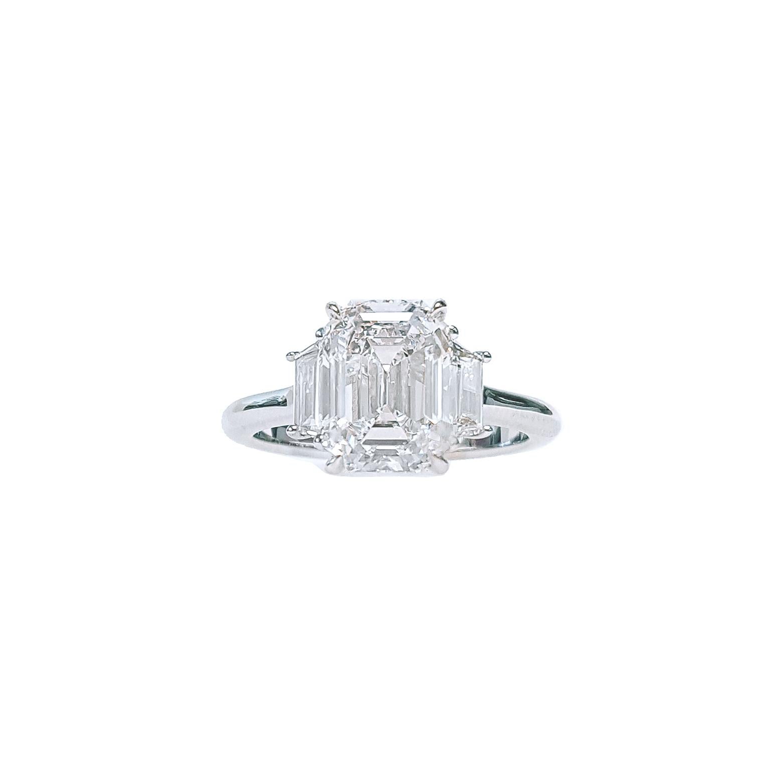 Magnifique bague de fiançailles à trois pierres serties d'un diamant de 3,02 carats taillé en émeraude et certifié par le GIA de couleur D et de pureté VS1. Le diamant central est élégamment accompagné de deux diamants de taille trapézoïdale d'un