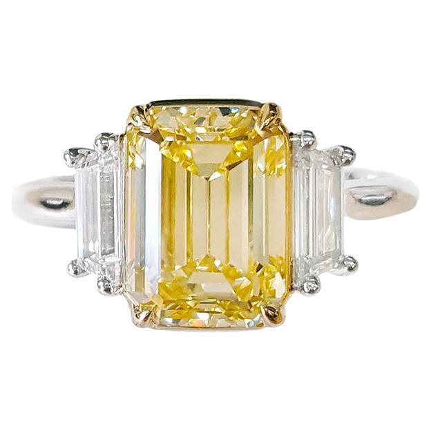 Anillo de compromiso de tres piedras con diamante amarillo fantasía natural talla esmeralda de 3 quilates GIA en venta