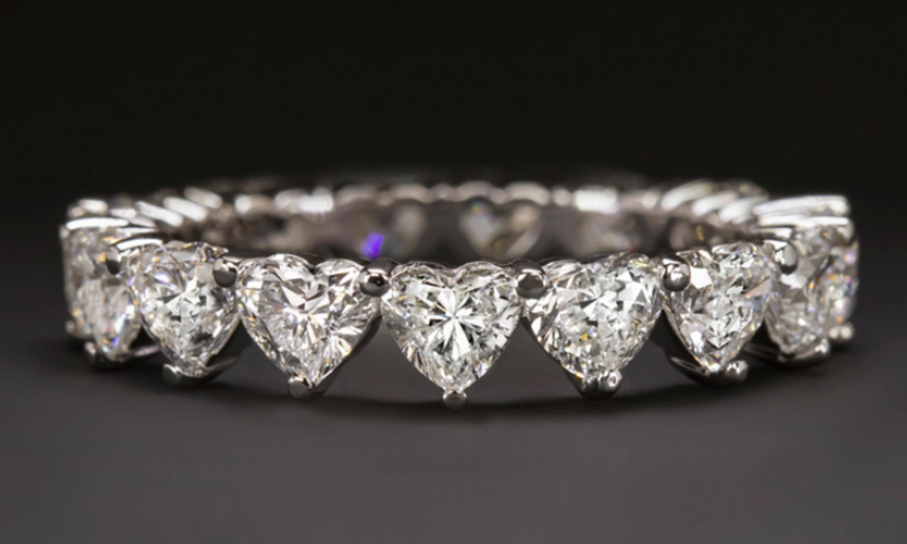 Eternity ring features approximately 3.04ct of vibrant heart shape diamonds set in an elegantly simple modern band. High quality, perfectly matched, and substantially sized diamonds cover the full diameter of the ring in dazzling sparkle. Bright