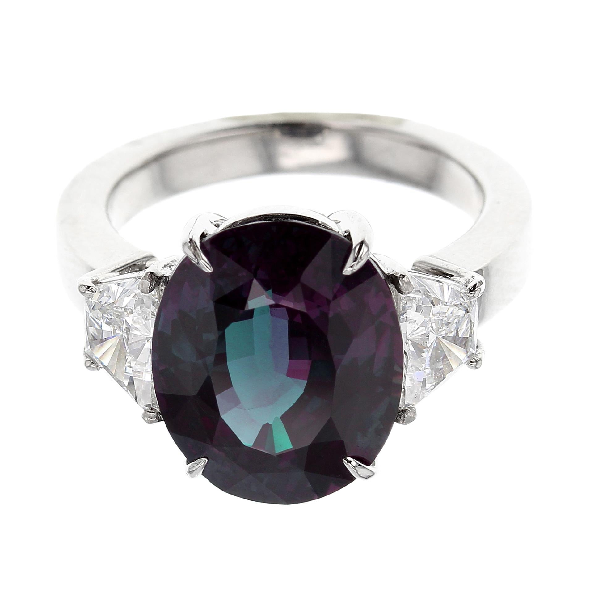 A beautiful oval shape, mixed-cut Brazilian Alexandrite, weighing over three carats, set with two trapezoid step-cut diamonds, set in Platinum. The stone accompanies a gemological certificate from AGL stating the origin as Brazil, with an 80 to 90%