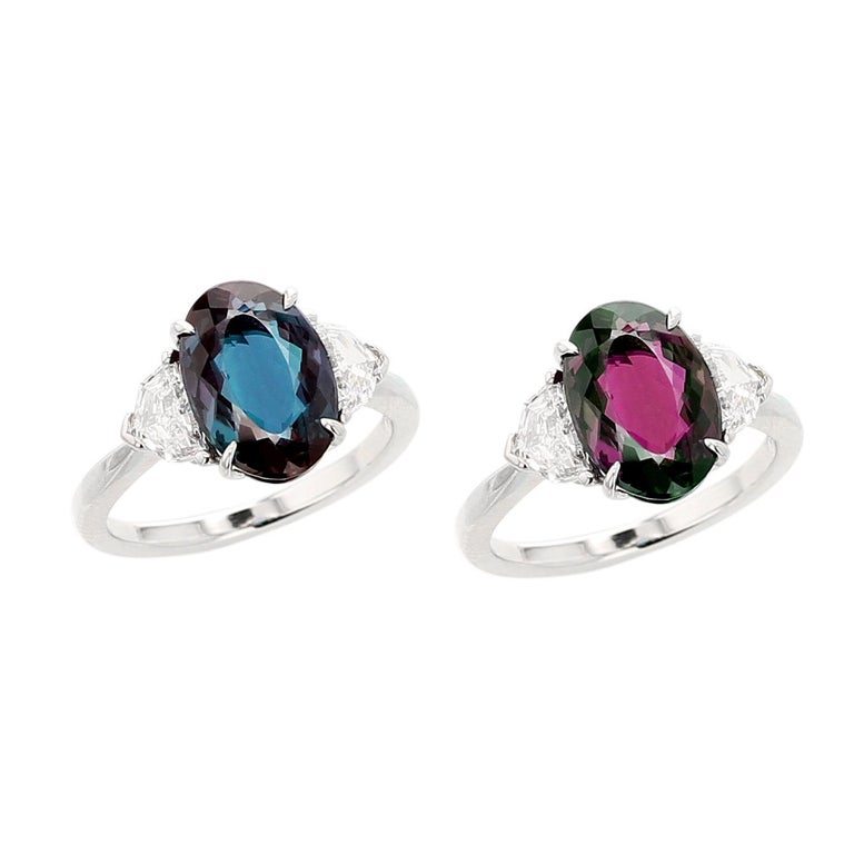 An elegant and classic three-stone alexandrite ring, centered with an oval mixed-cut natural, no-heat Brazilian Alexandrite weighing well over three carats, accented with two shield step-cut diamonds weighing 0.64 carats, with an estimate