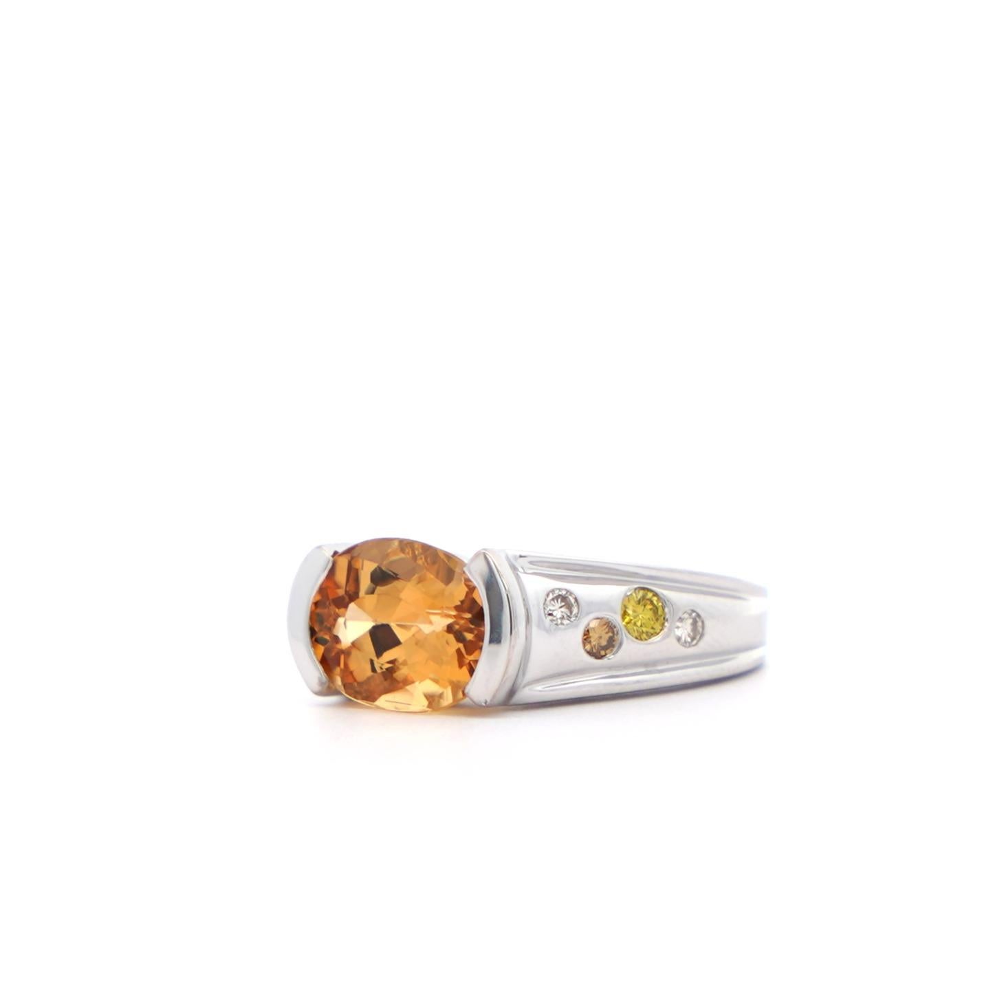 A precious topaz and diamond ring, set in 18k solid white gold. Centering a yellowish orange precious topaz center stone, oval brilliant cut for optimal color balance and brilliance. Featuring a chic east-west half-bezel setting. Adorned with a