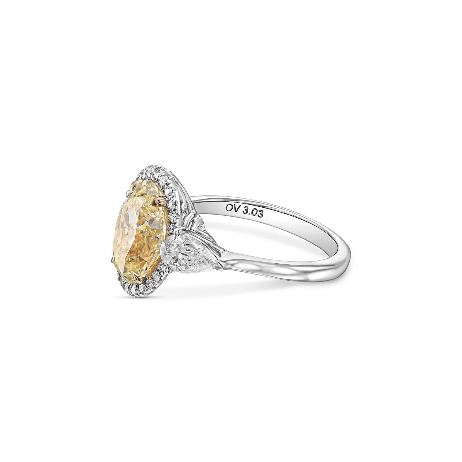 Presenting a stunning Three-Stones Halo Engagement ring featuring a 3..03 carat W to X Oval cut diamond, IGI certified as VS1 in clarity in its center. Elegantly flanked by two pear-cut diamonds with a total weight of 0.74 carat. The classic design