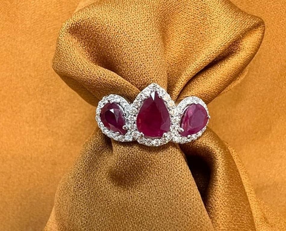 Ruby Weight: 3.09 CTs, Measurements: 8x6/7x5 mm, Diamond Weight: 0.47 CTs (1.3 mm), Metal: 18K White Gold, Gold Weight: 6.04 gm, Ring Size: 7, Shape: Pear, Color: Red, Hardness: 9, Birthstone: July