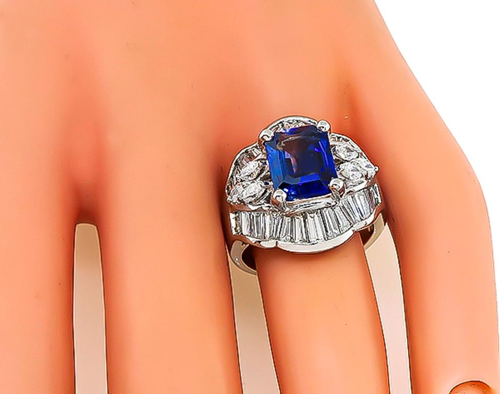 This fabulous platinum ring ring is centered with a lovely emerald cut sapphire that weighs 3.00ct. The sapphire is accentuated by sparkling baguette and marquise cut diamonds that weigh 2.56ct. graded H color with VS clarity. The ring is stamped