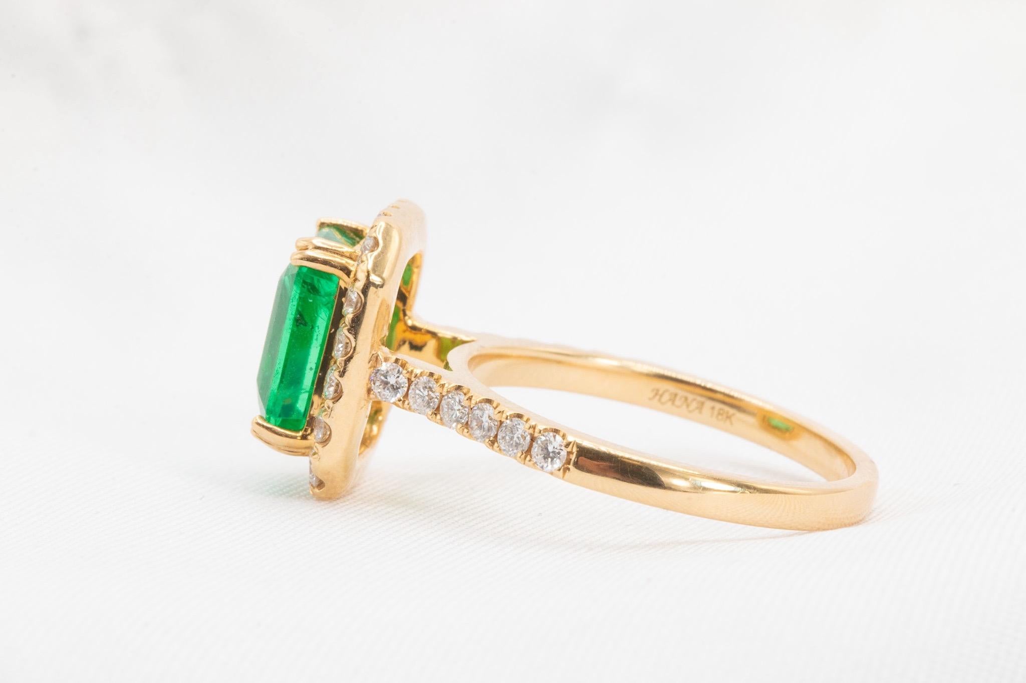 This classic halo ring showcases an approximately 2.49-carat vivid green Zambian emerald, surrounded by approximately 0.54 carats of sparkling white diamonds, graded VS in clarity. Crafted in 18k yellow gold, this timeless design is perfect as an