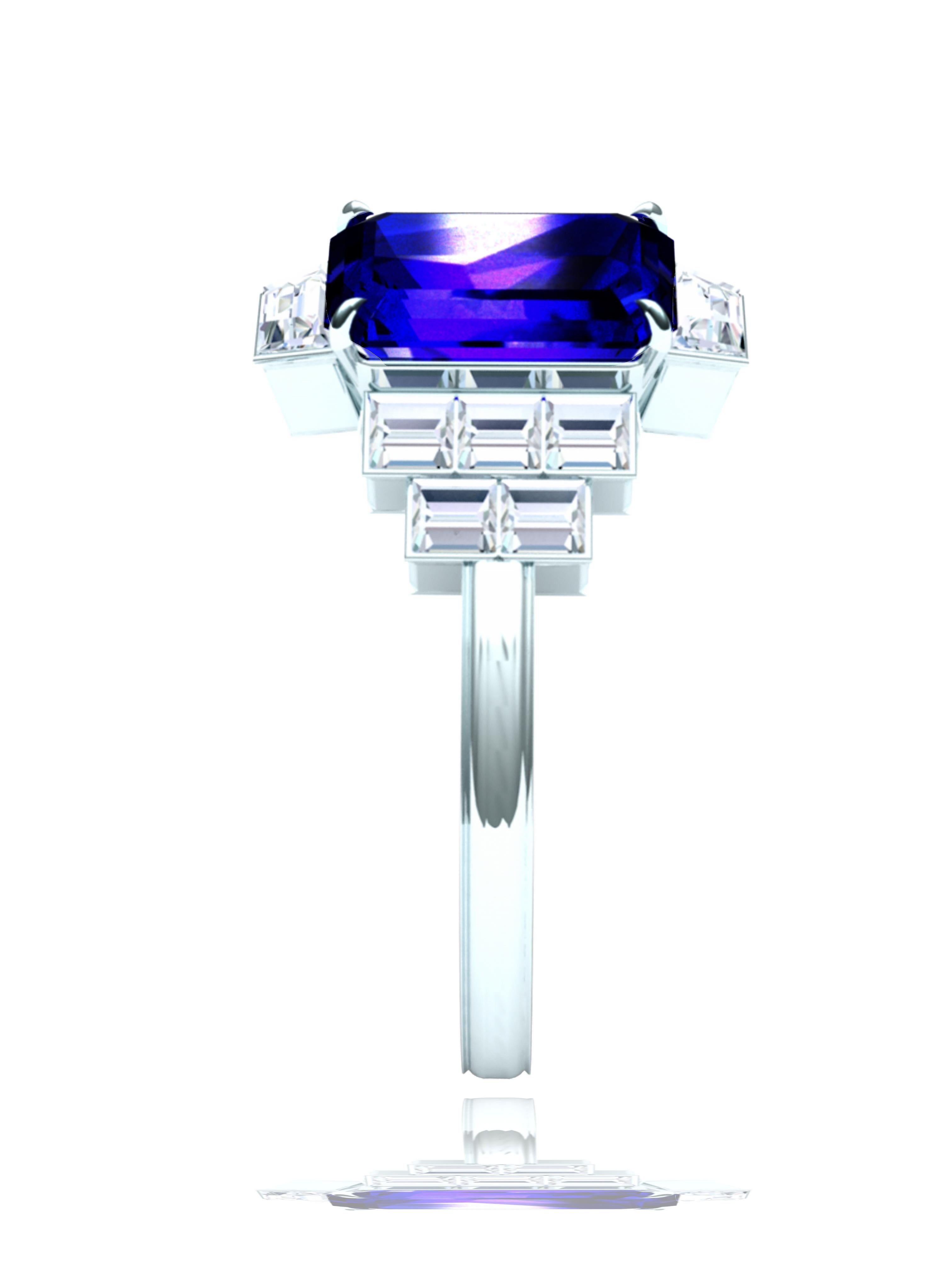 A gorgeous deep violet purple blue Tanzanite with ribbons of red refracting describes the center stone of this ring.  The center is a emerald cut Tanzanite that weighs apprx. 2 carats.  The center is flanked by two trapezoid step cut diamonds each