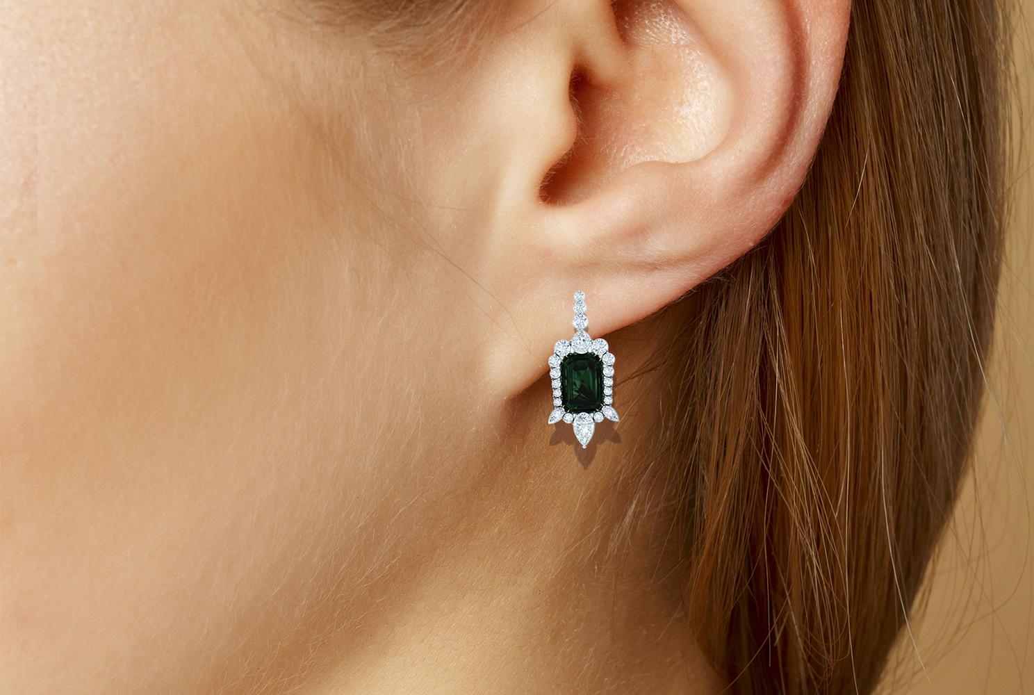 This beautiful pair of Tourmaline and Diamond earrings has a classic look that never goes out style.  The center stone on earring is a 1 carat blue green emerald cut Tourmaline.  The total carat weight of the Tourmalines are 2 carats.  There is also