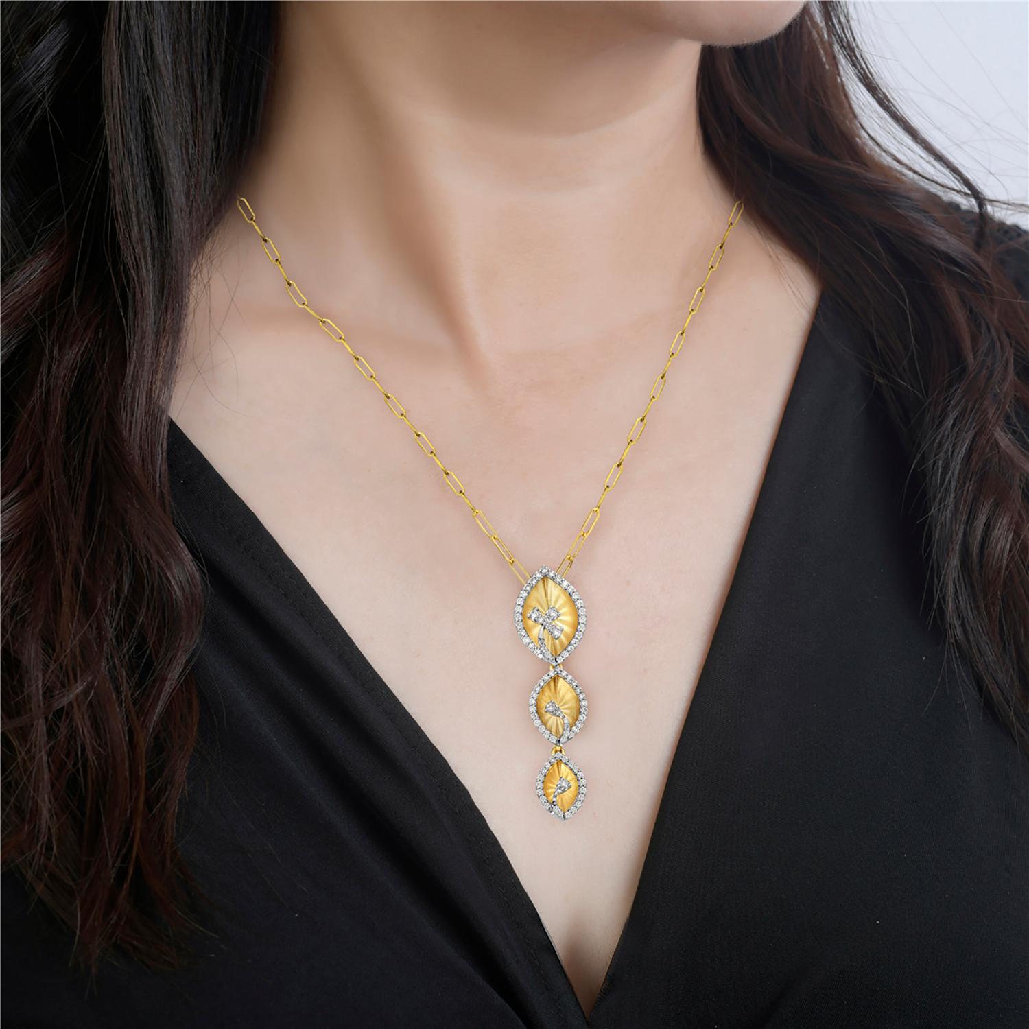This beautiful pendant showcases three intricately carved leaves, each one with its own unique shape and texture. A shimmering halo of diamonds surrounds the leaves, providing a luxurious touch of glamour. Crafted from high-quality 14k yellow gold,