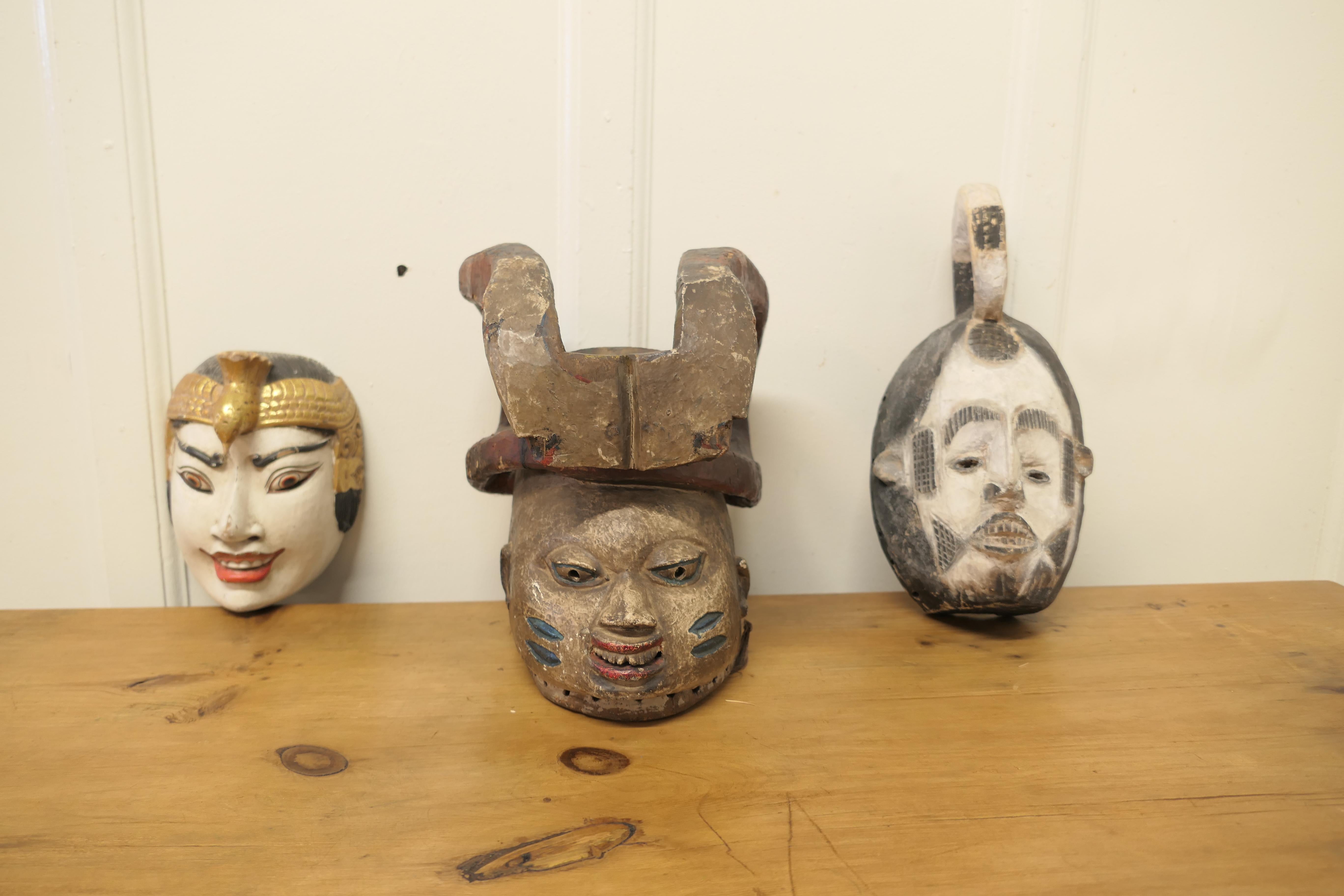 3 carved wooden Ceremonial Masks from Nigeria, Africa and Indonesia

These are unusual pieces, they are all carved in wood and painted
One is a Yorubastam Gelede from Nigeria, it dates from the 19th Century and would have been used in fertility