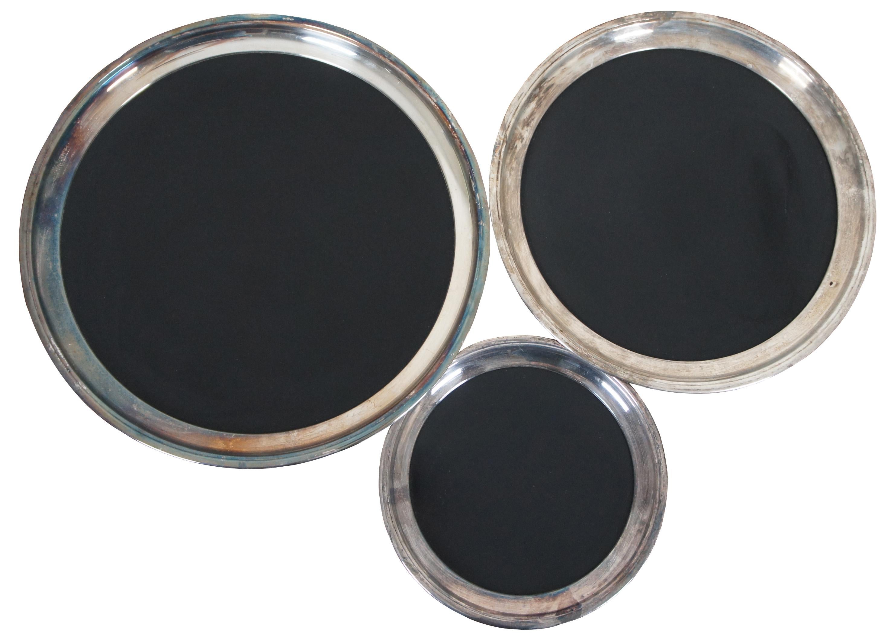 Set of three mid century Crescent silver plate and black Formica round serving trays.

Large - 16.5” x 1” / Medium - 14.25” x 1” / Small - 10” x 0.75” (Diameter x Height).