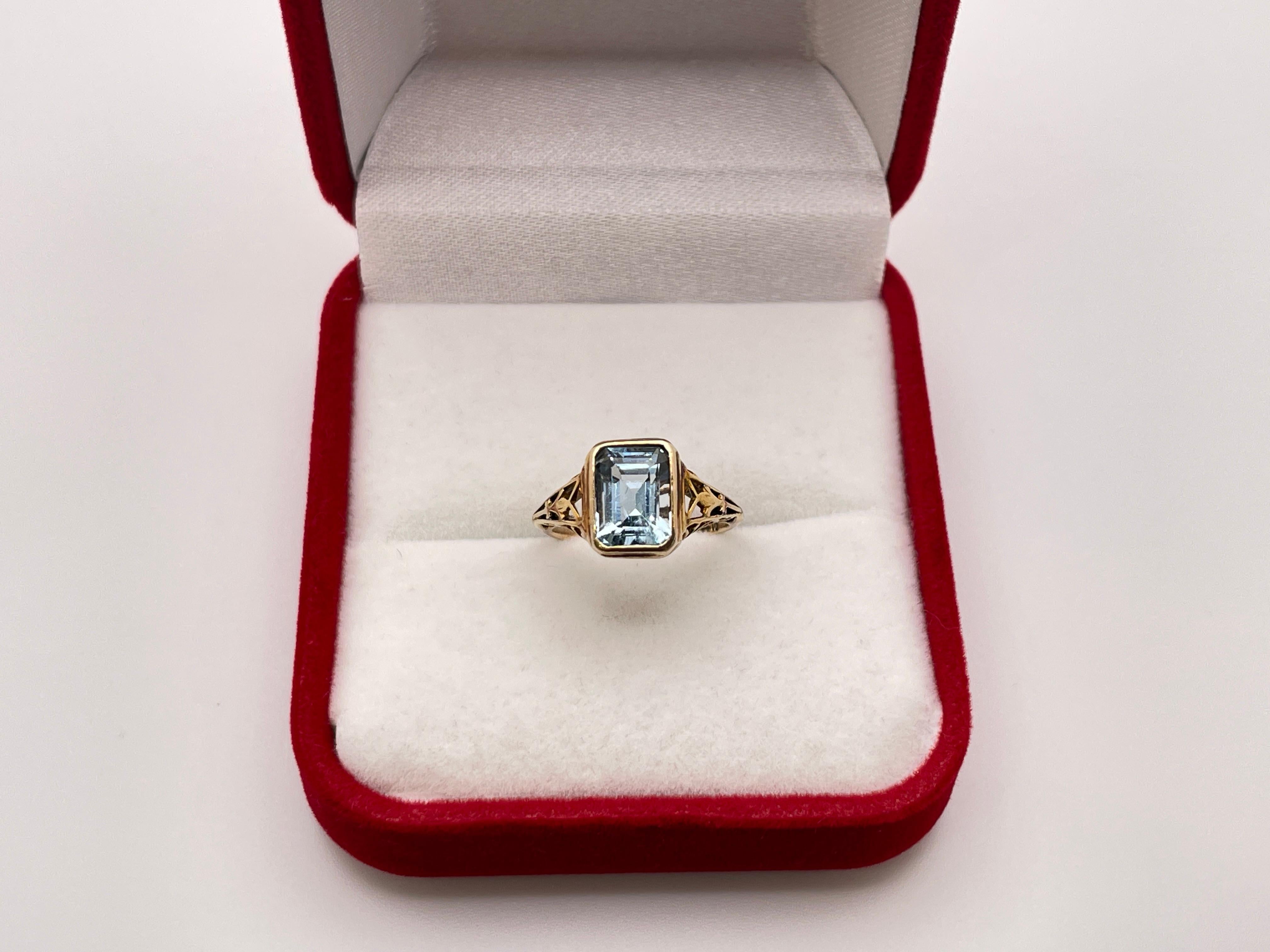 An original 14K yellow gold Art Deco filigree aquamarine engagement ring, mounted with a beautiful emerald cut blue aquamarine weighing approximately 3 CT. The setting and base showcase a magnificent hand-crafted filigree design.


Details
 - Gross