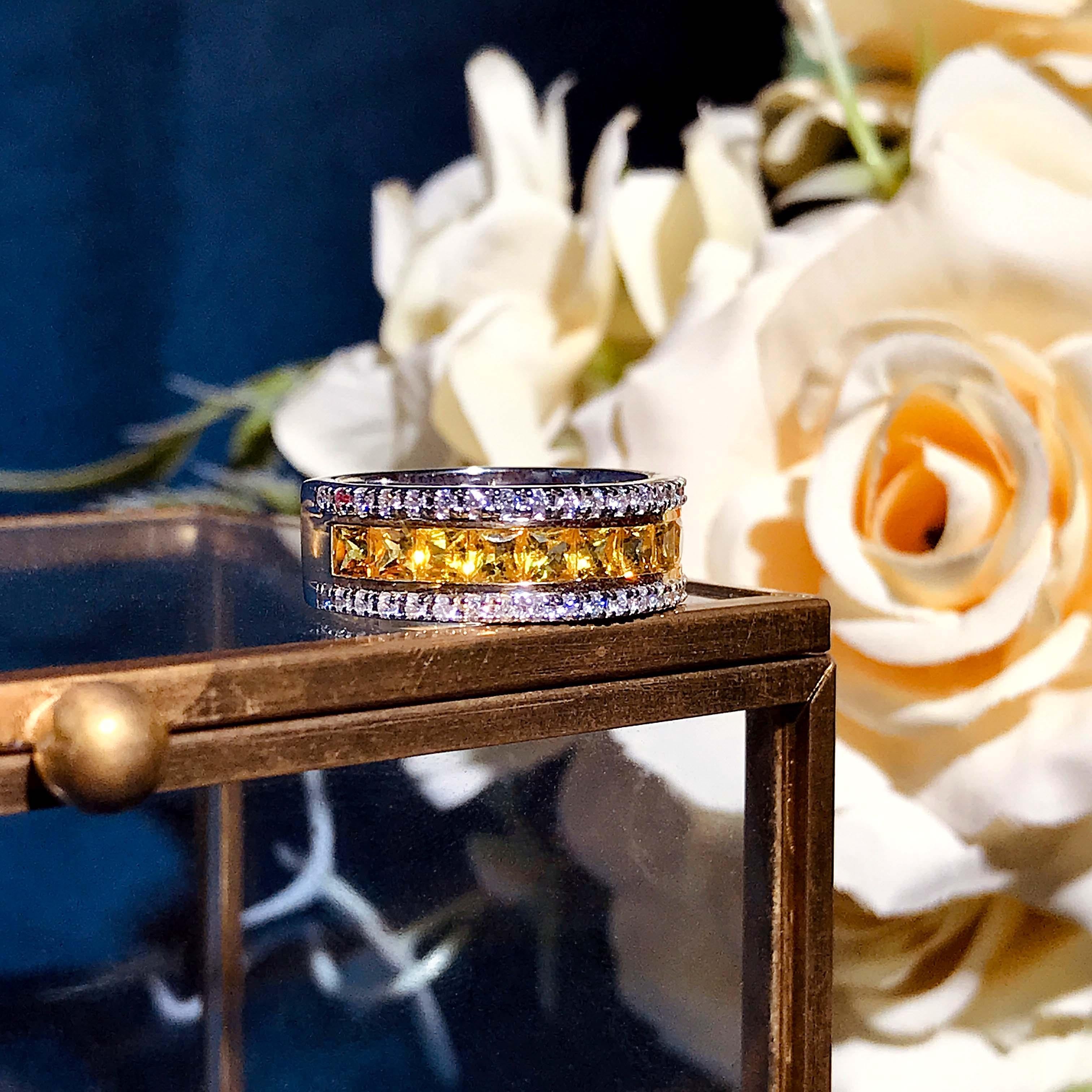 Here is a ring you will fall in love for an eternity. This..  3 carat Asscher cut yellow sapphire band is a unique take on a favorite. Featuring top and bottom rows of 0.46 carat round brilliant cut diamonds, this 18k gold ring is a vision of