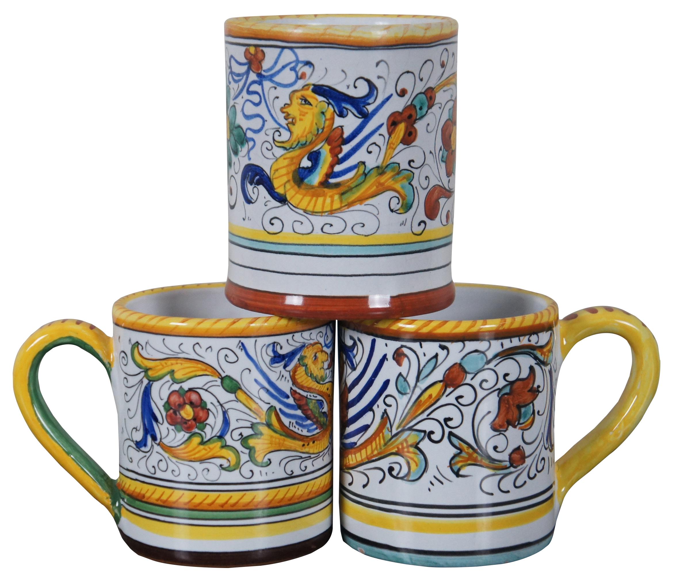 Vintage hand made Deruta, Italy, set of three majolica ceramic mugs, painted with the Raffaellesco dragon. Hand made in Deruta, Italy.

Among the most popular and enduring Italian majolica patterns, the classic “Raffaellesco” traces its origin to