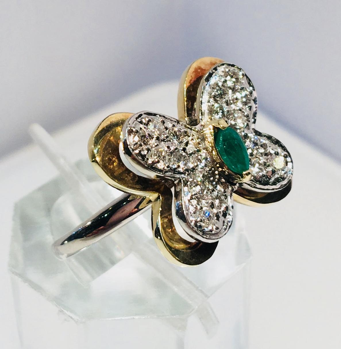Sweet estate butterfly ring features a prong set, marquise cut green emerald body and pave set diamond wings.  The face of the ring is 14 karat white gold, with a separate, larger yellow gold butterfly outline underneath the face., creating a 3