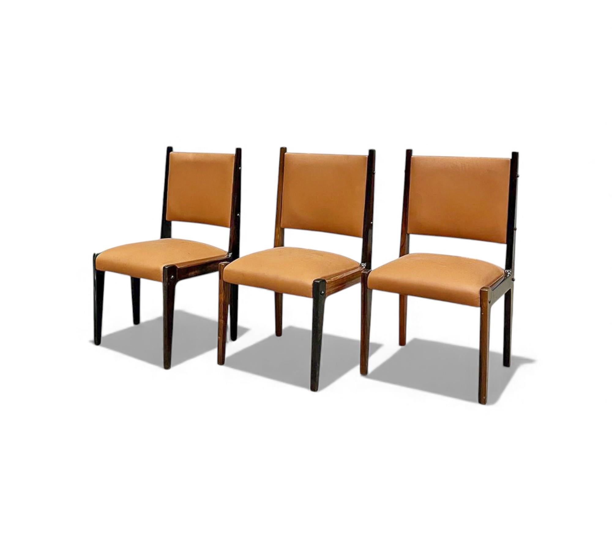 Each of these chairs features a solid rosewood frame paired with light brown leather upholstery, presenting a clean, almost brutalist aesthetic. Originally designed for Bloch Editors—a major Brazilian publishing and broadcasting conglomerate—these