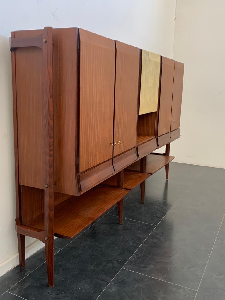 Three-door highboard in teak and parchment in the style of Silvio Cavatorta.
This piece was designed in the style of designer Silvio Cavatorta. A 1960s highboard of eye-catching design. The cabinet has three doors, the side parts are two-door with