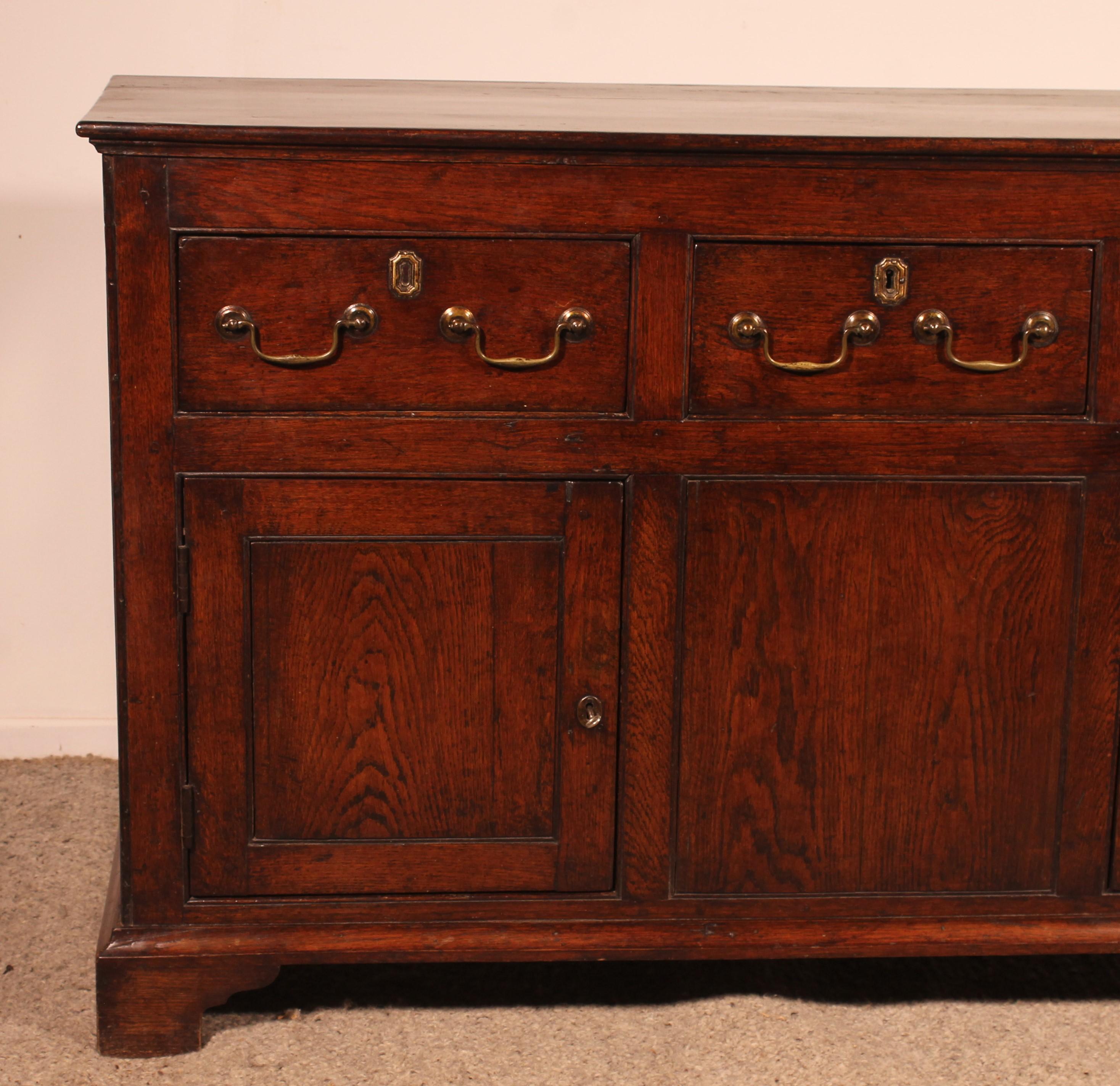 lovely dresser base with 2 doors and three drawers from the 18th century in oak
Very elegant sideboard of small proportions which opens with two leaves with very pure lines typical of 18th century English furniture

Very beautiful top with a
