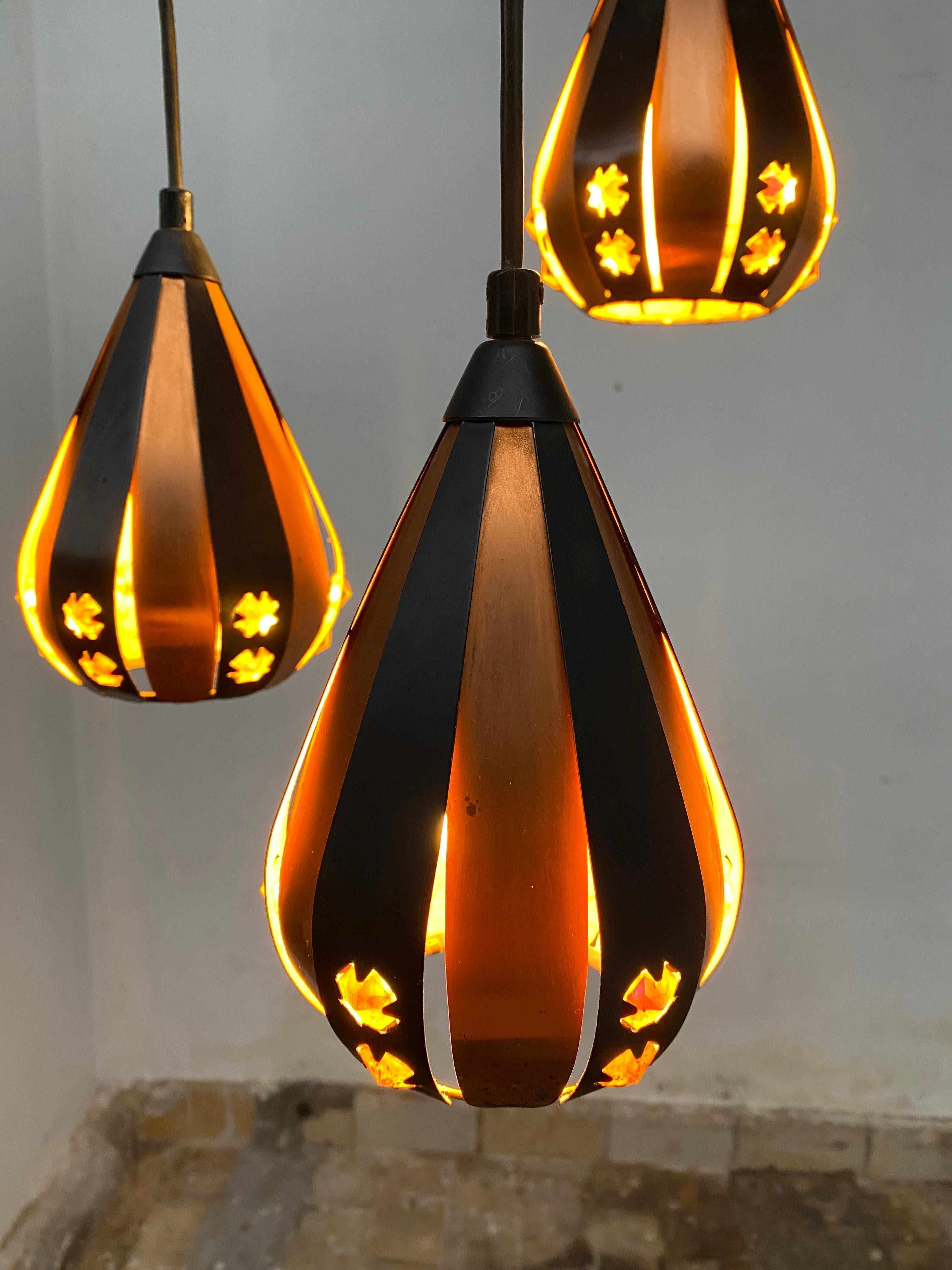 Lustre avec trois magnifiques lampes suspendues en forme de goutte d'eau par Werner Schou pour Coronell Electrical Denmark produit vers 1970

Fabriqué à partir de cuivre, de lamelles de métal noir et de morceaux de verre rectangulaires taillés.

Ce
