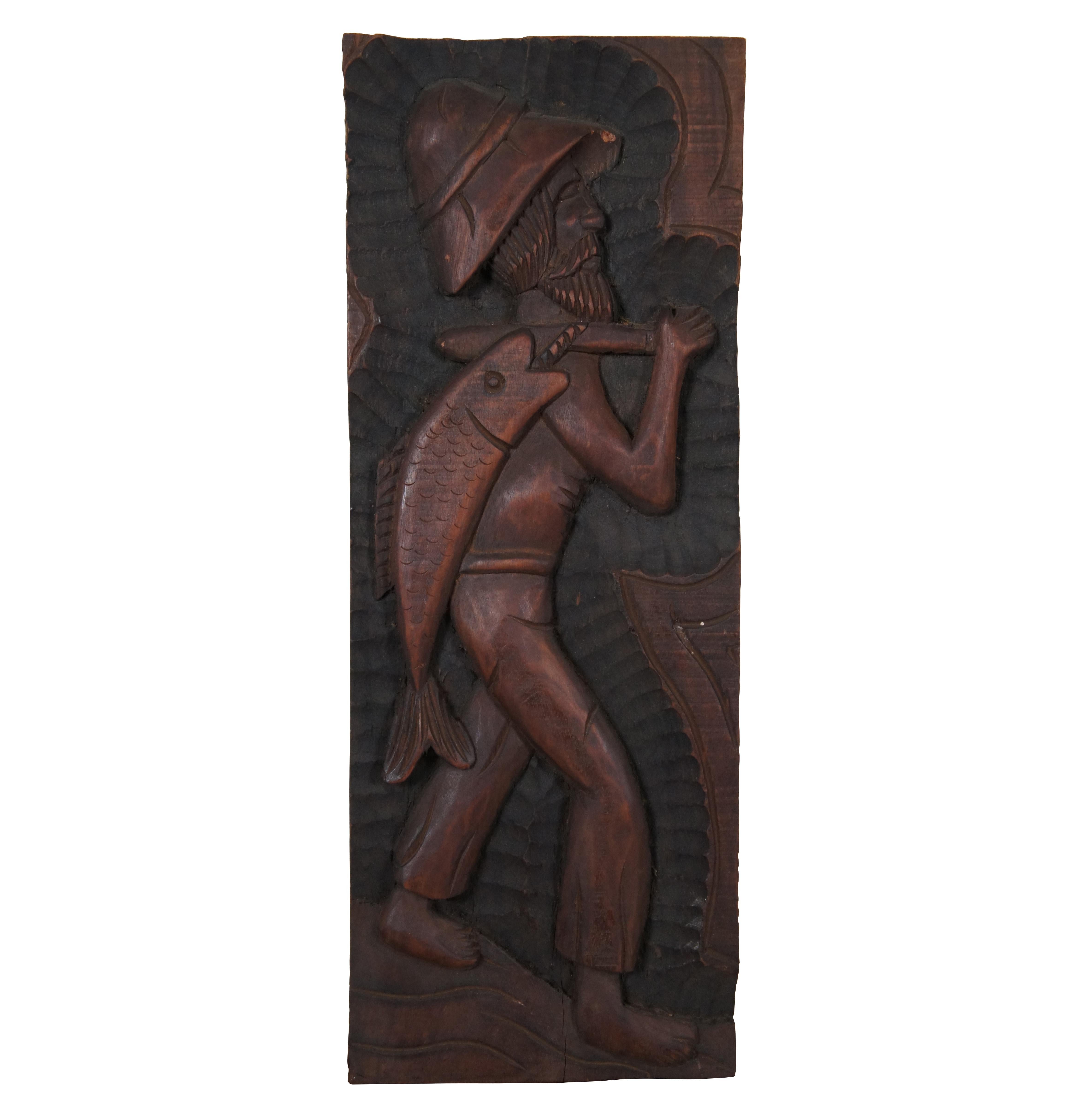 Set of three vintage folk art style carved wooden relief wall hangings, showing a fisher man with a large fish, a sailboat or raft, and a farmer with baskets of vegetables. Signed on verso – two signed Xikdlu and one signed Dalva.