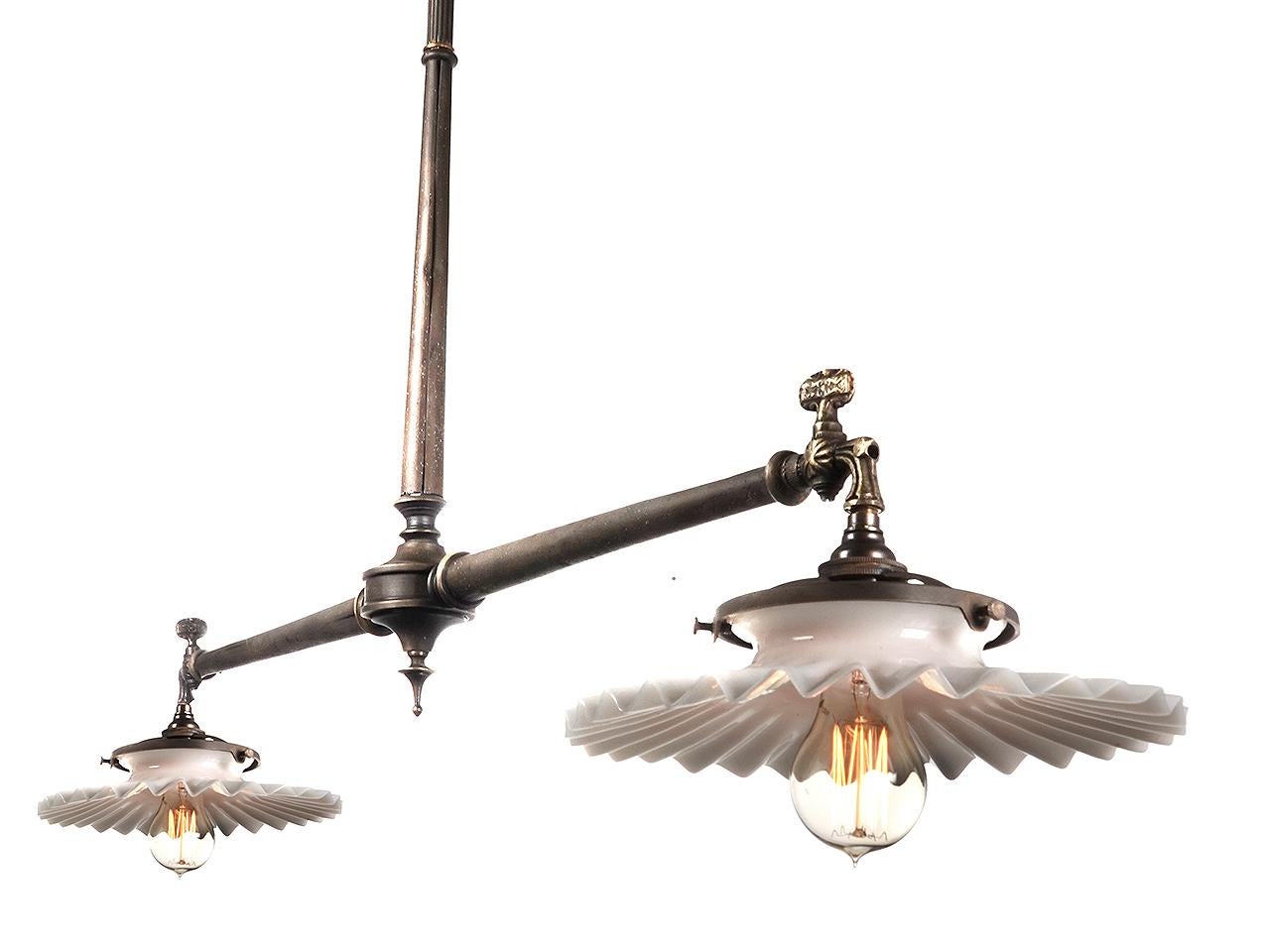 This was the type of double lamp found over store counters from the mid to late 1800. They were simple, utilitarian but still very stylish in detail. This example was refitted to now take a candelabra bulb. It spans an 3 foot and uses two original