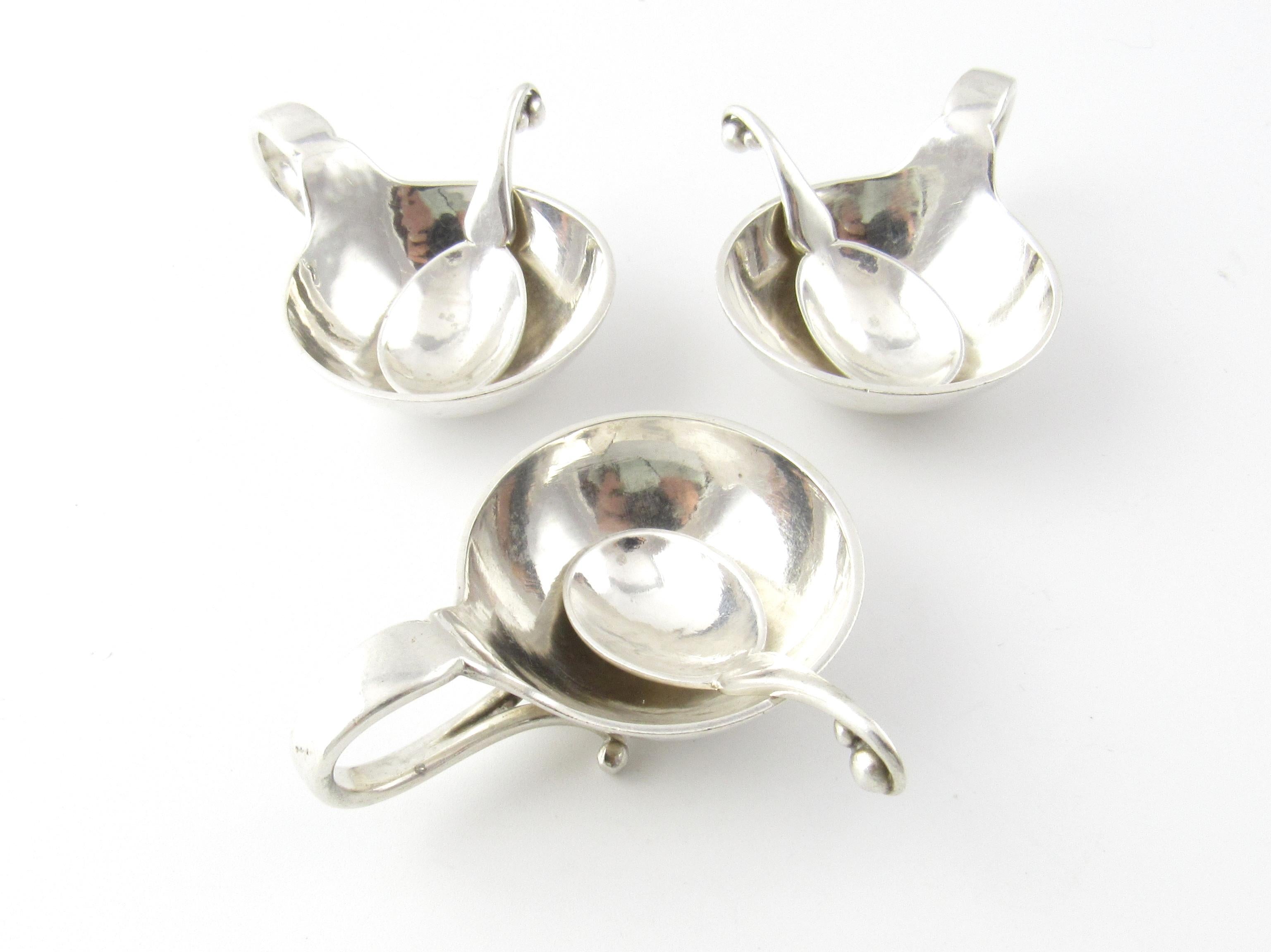 3 George Jensen Sterling Silver Salt Cellars and Matching Spoons #110

This is a beautiful set of three sterling silver salt cellars with hammered surface and matching spoons by George Jensen.

Measurement: Salt cellars measures 1 and 3/8 inches in